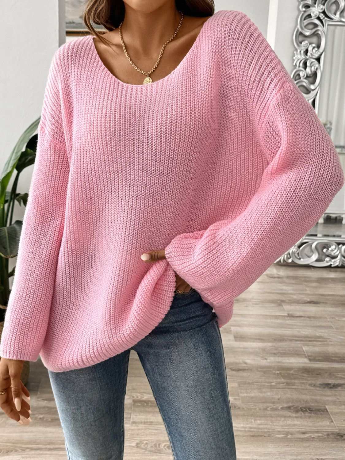 Pink round neck long sleeve sweater with moderate stretch, styled with casual jeans