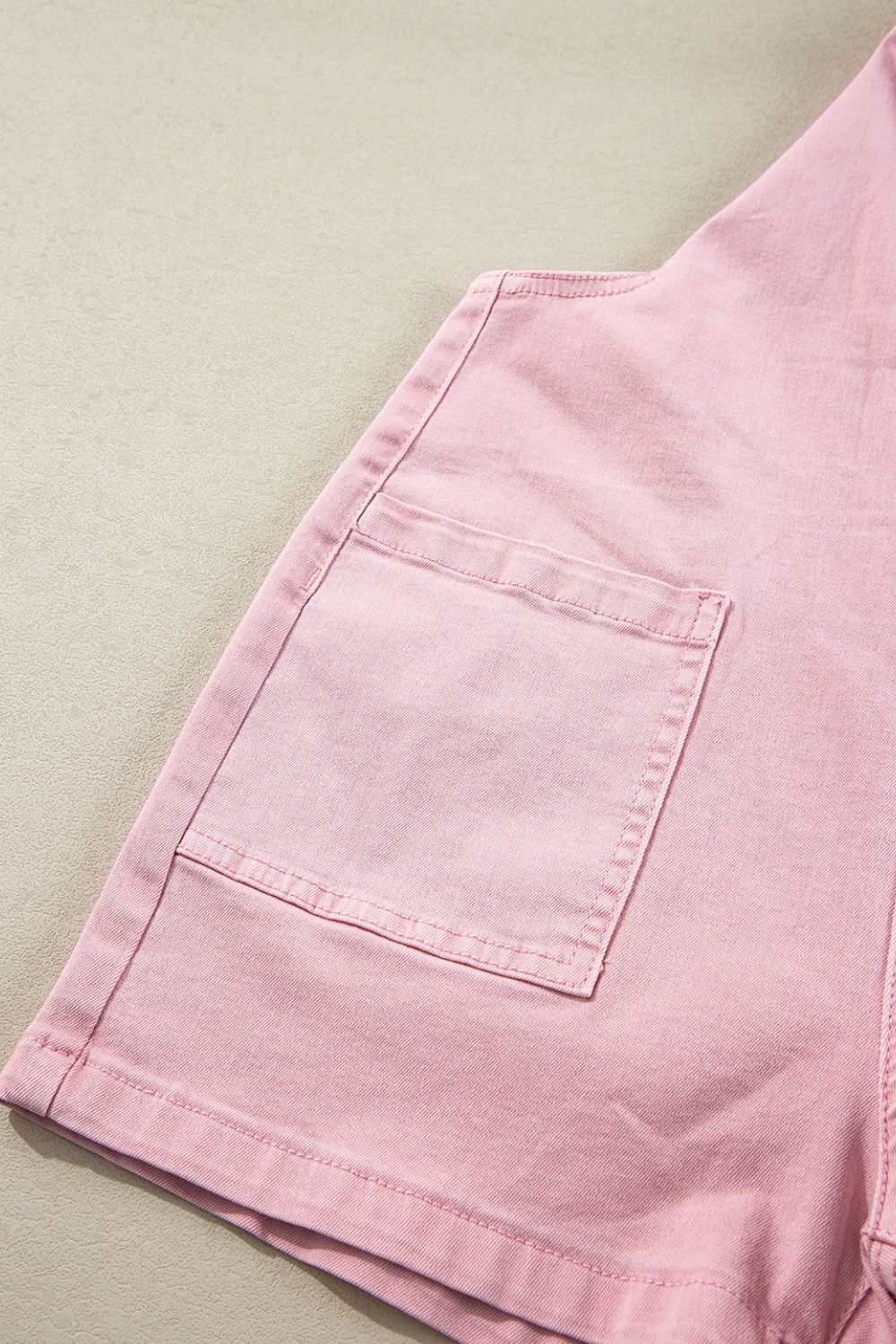 Pink denim overalls with knot straps and side pocket detail.