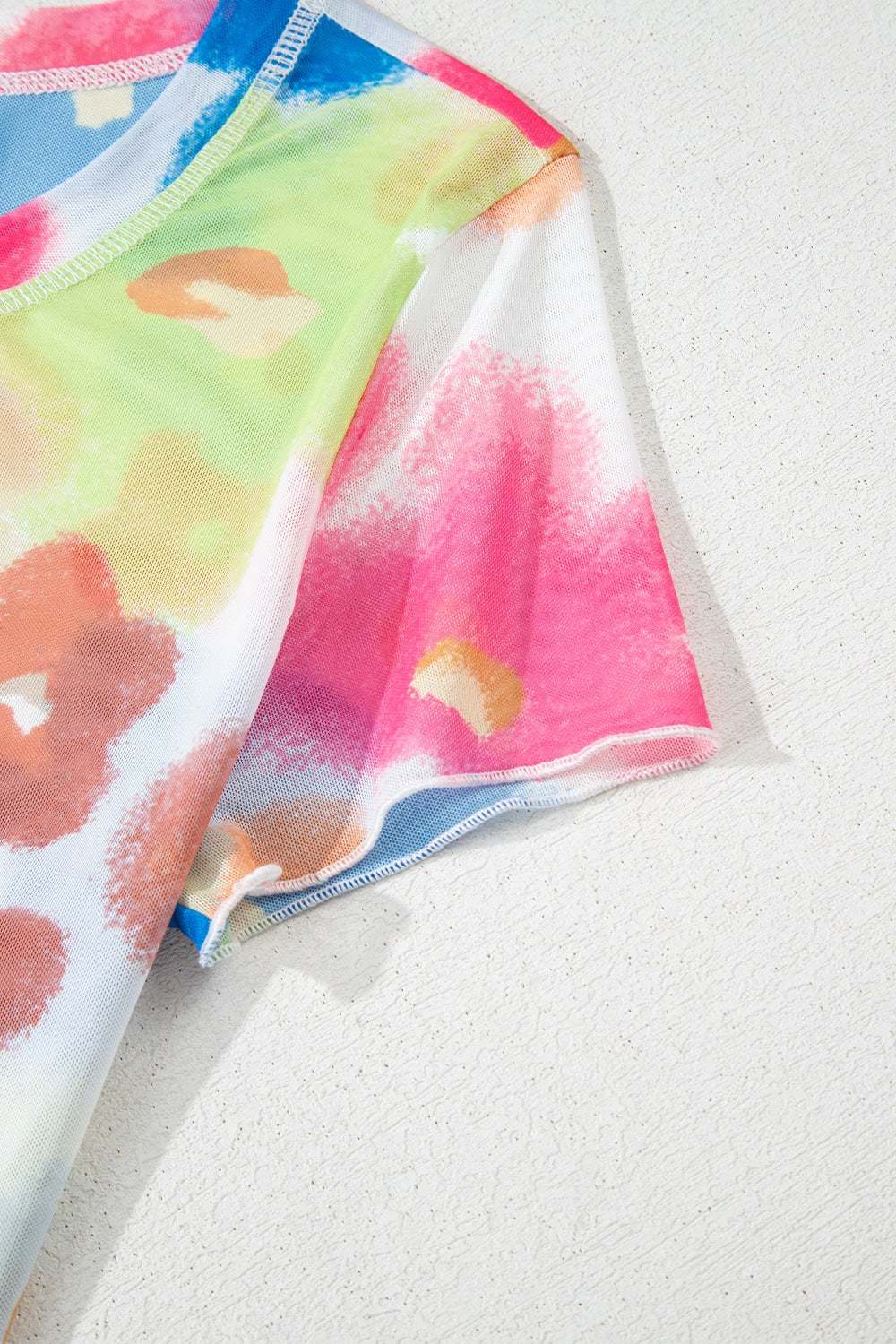 Printed round neck short sleeve blouse with colorful abstract design.