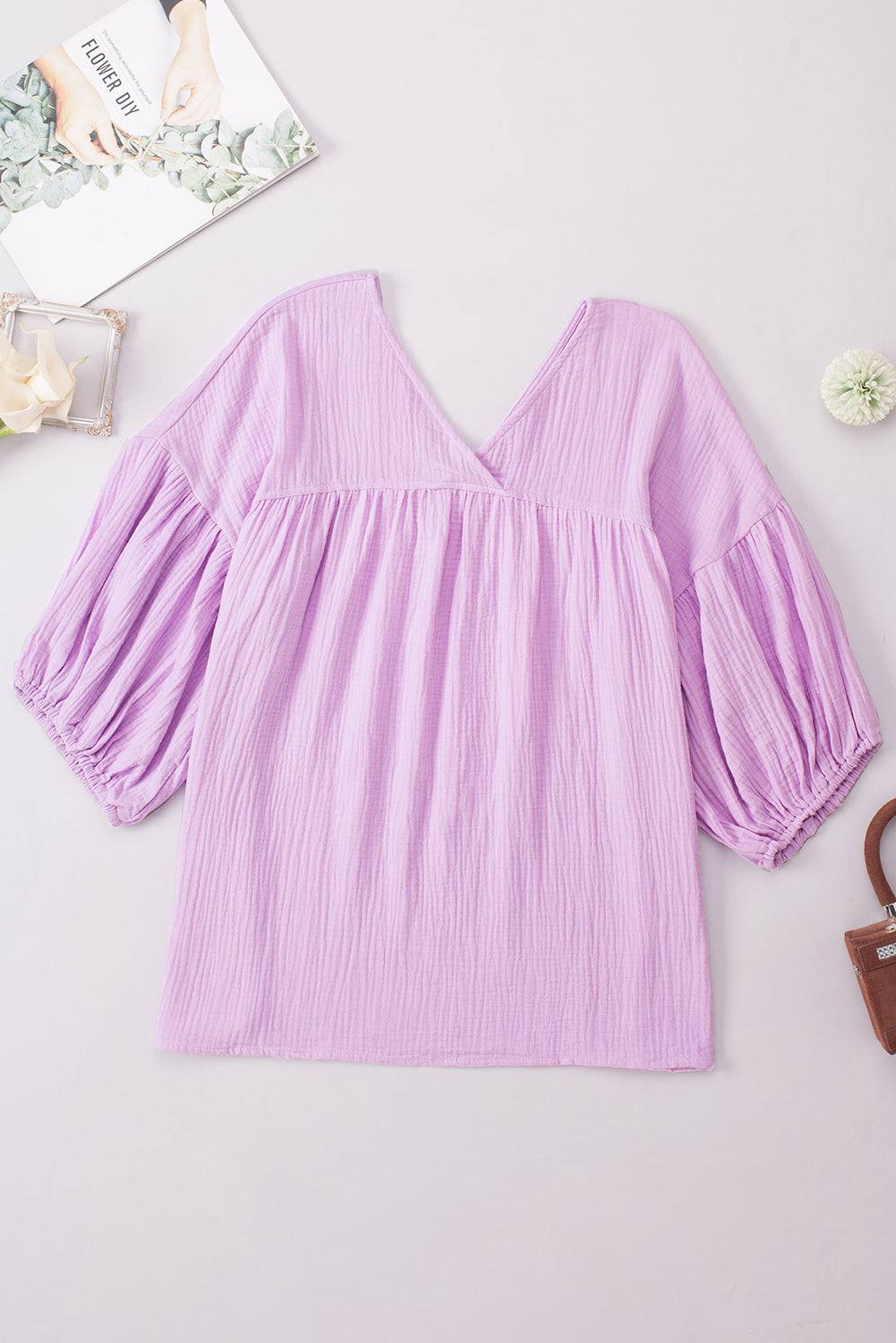 Casual solid-colored V-neck blouse with dropped shoulders and long sleeves.