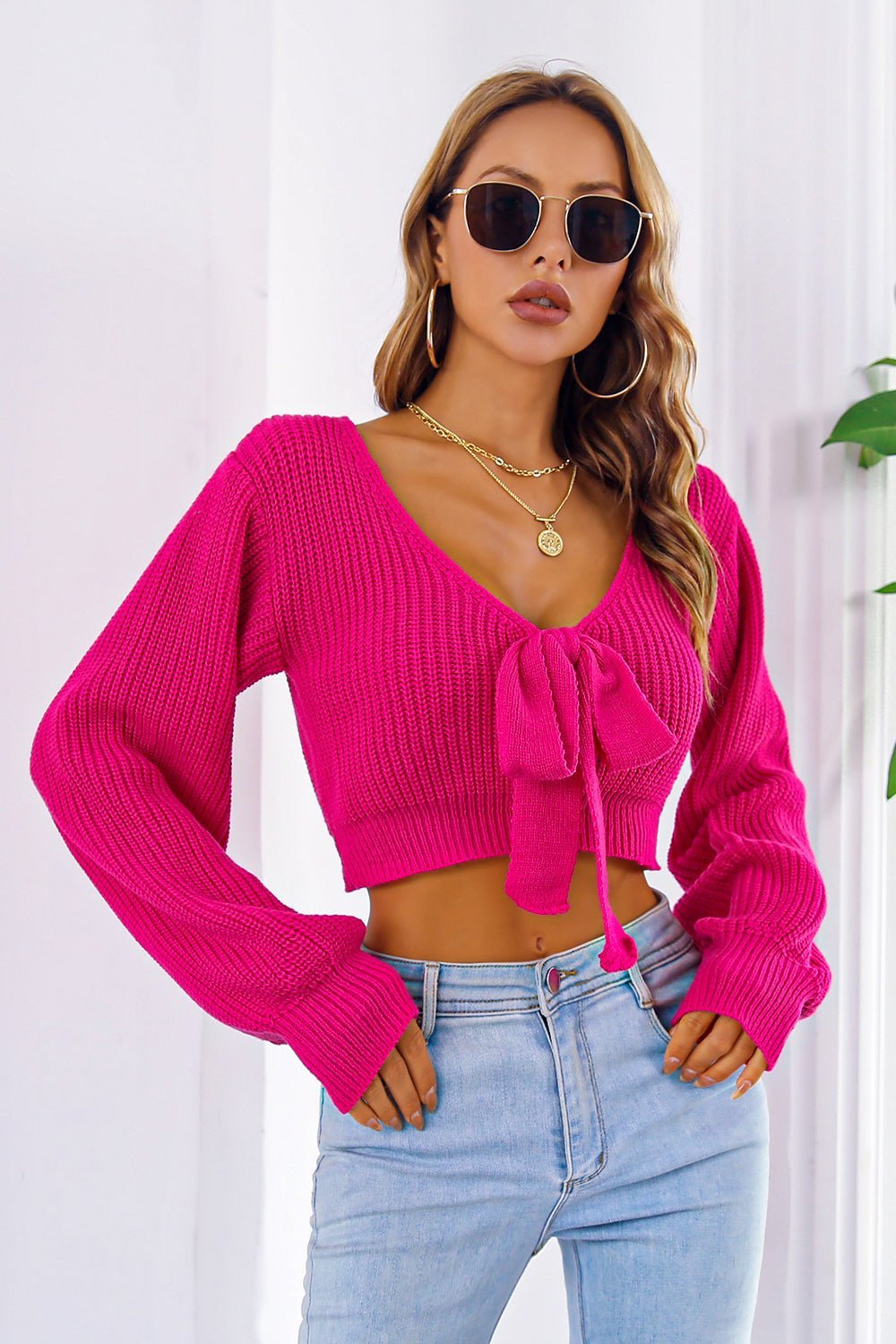 Bow V-Neck Long Sleeve Cropped Sweater in pink, slightly stretchy acrylic material.