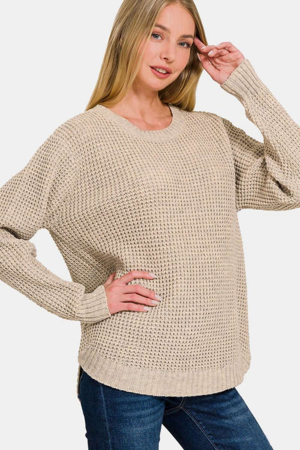 Women wearing beige waffle knit high low long sleeve sweater with relaxed fit and round neckline