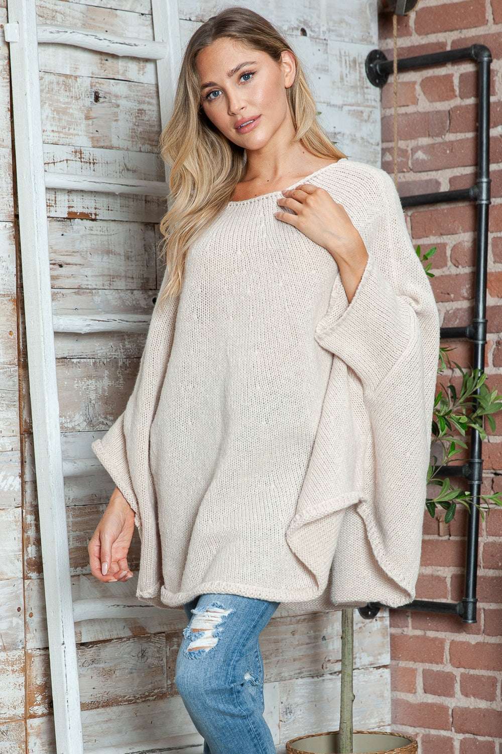 Cozy round neck batwing sleeve sweater in beige, slightly stretchy polyester material.