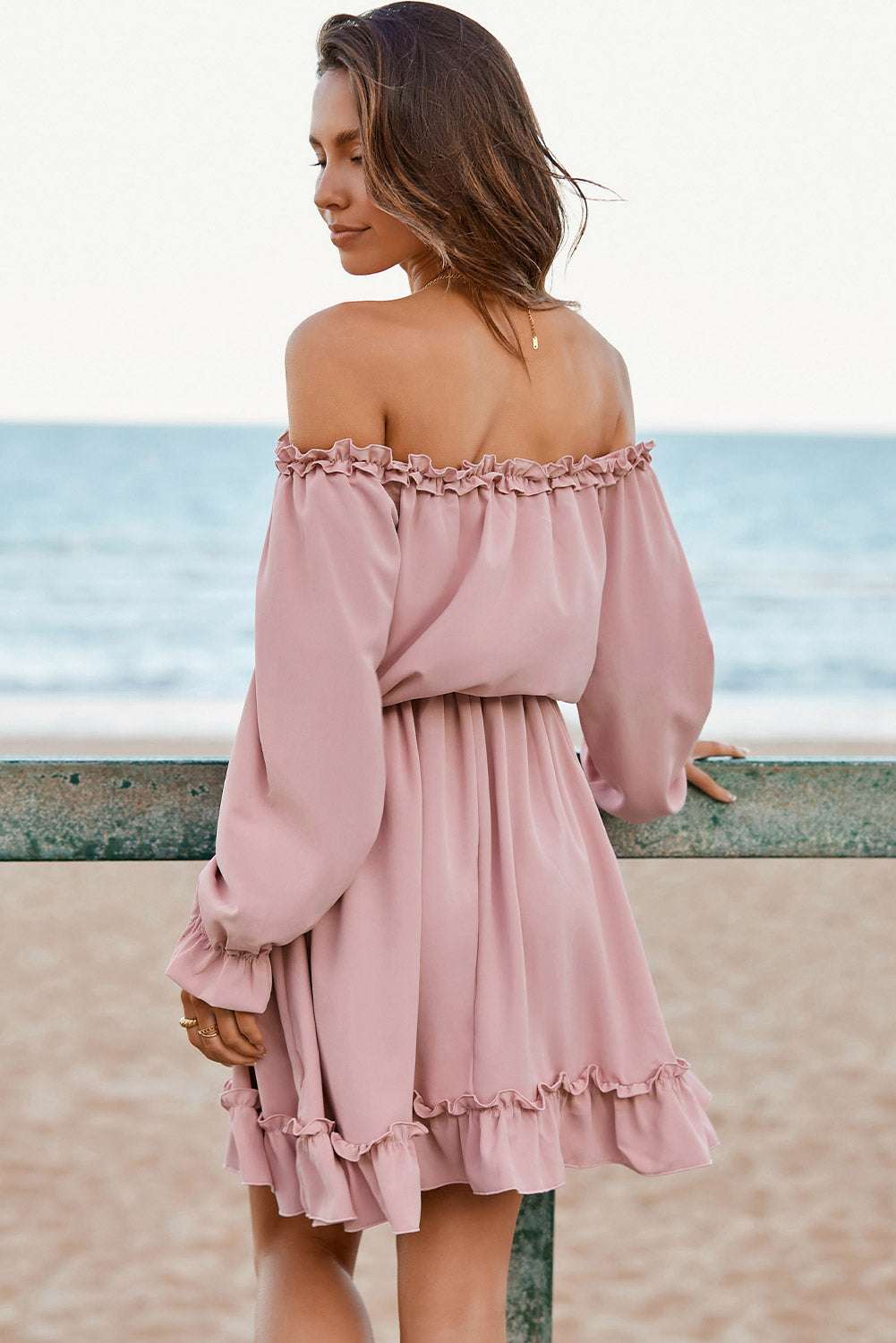Frill off-shoulder flounce sleeve dress in pink by the beach.