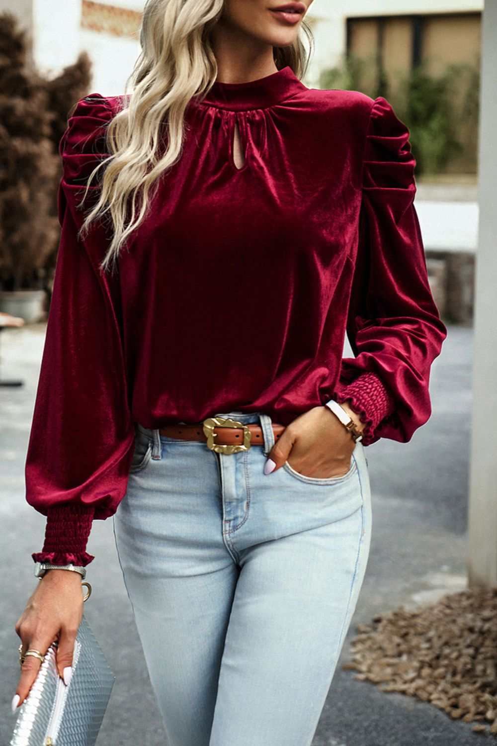 Mock neck velvet long sleeve blouse with tie accents, in a rich burgundy shade, paired with light wash jeans.