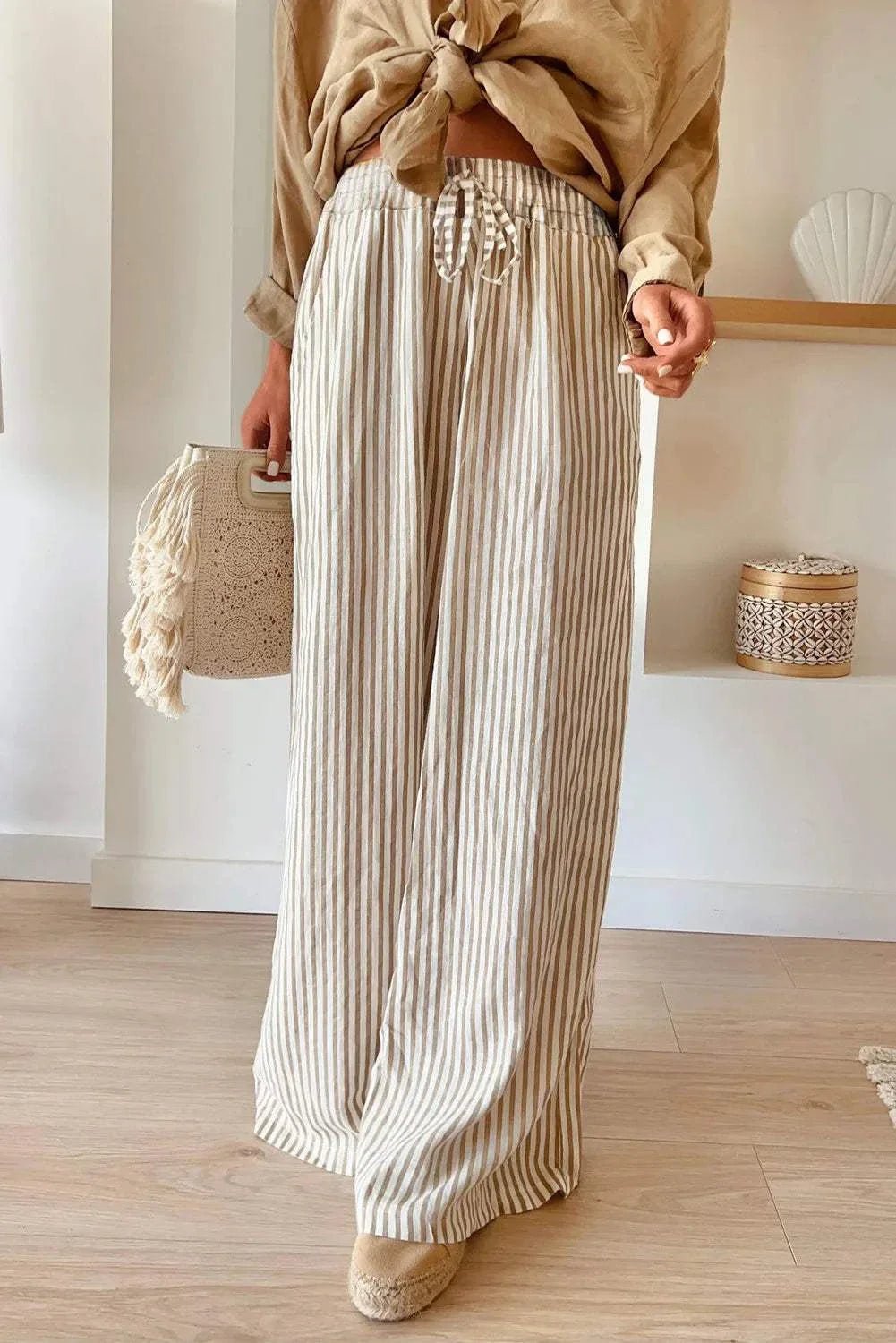 Striped wide leg pants with drawstring, featuring pockets and made from 100% polyester.