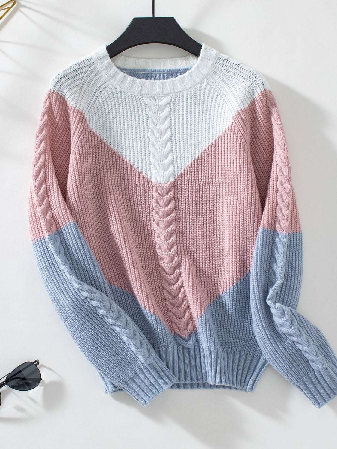 Color block round neck long sleeve sweater in pink, white, and blue with a cable knit pattern.