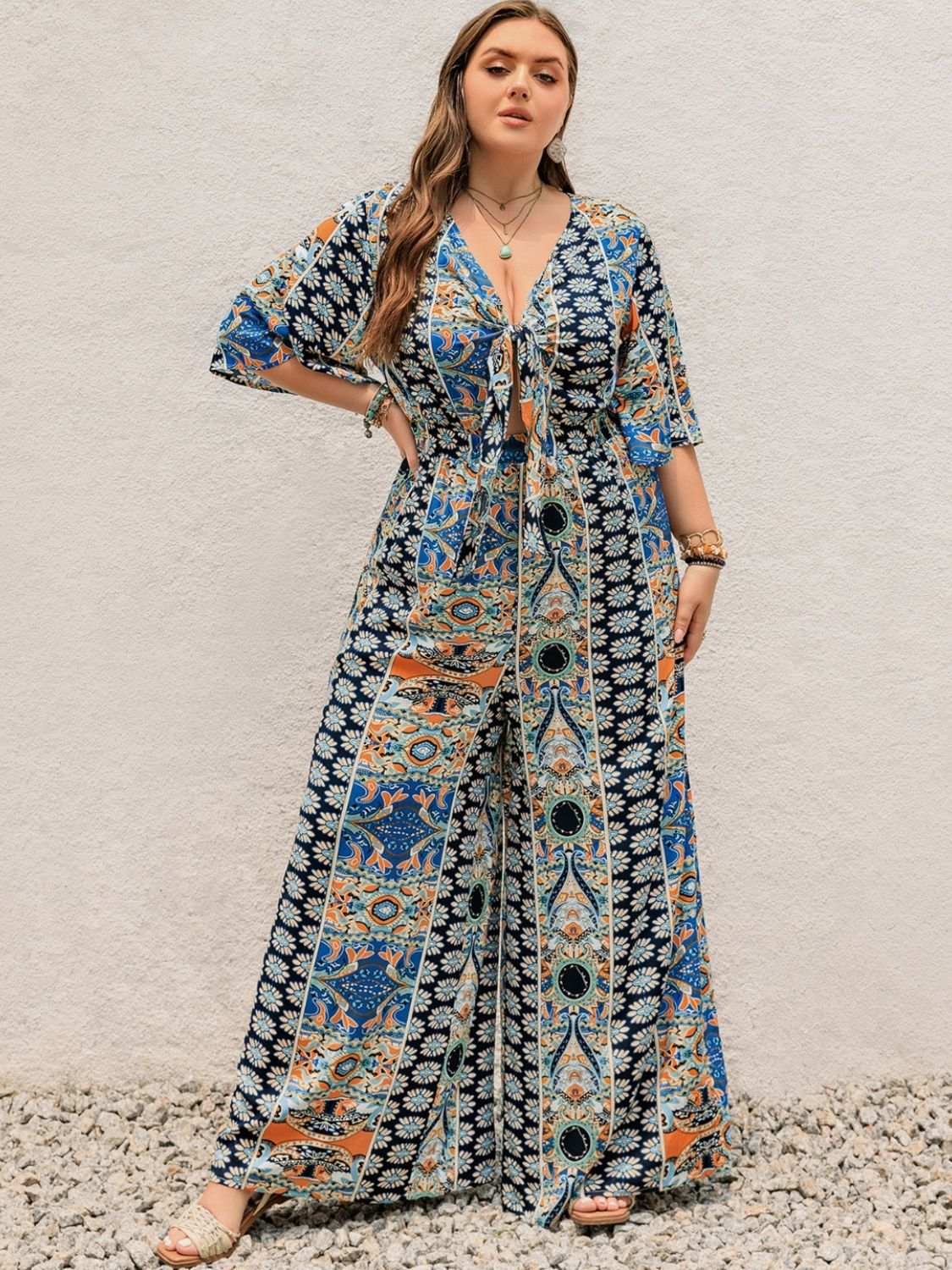 Plus size printed half-sleeve wide-leg jumpsuit in vibrant colors, showcasing a tied waist design.