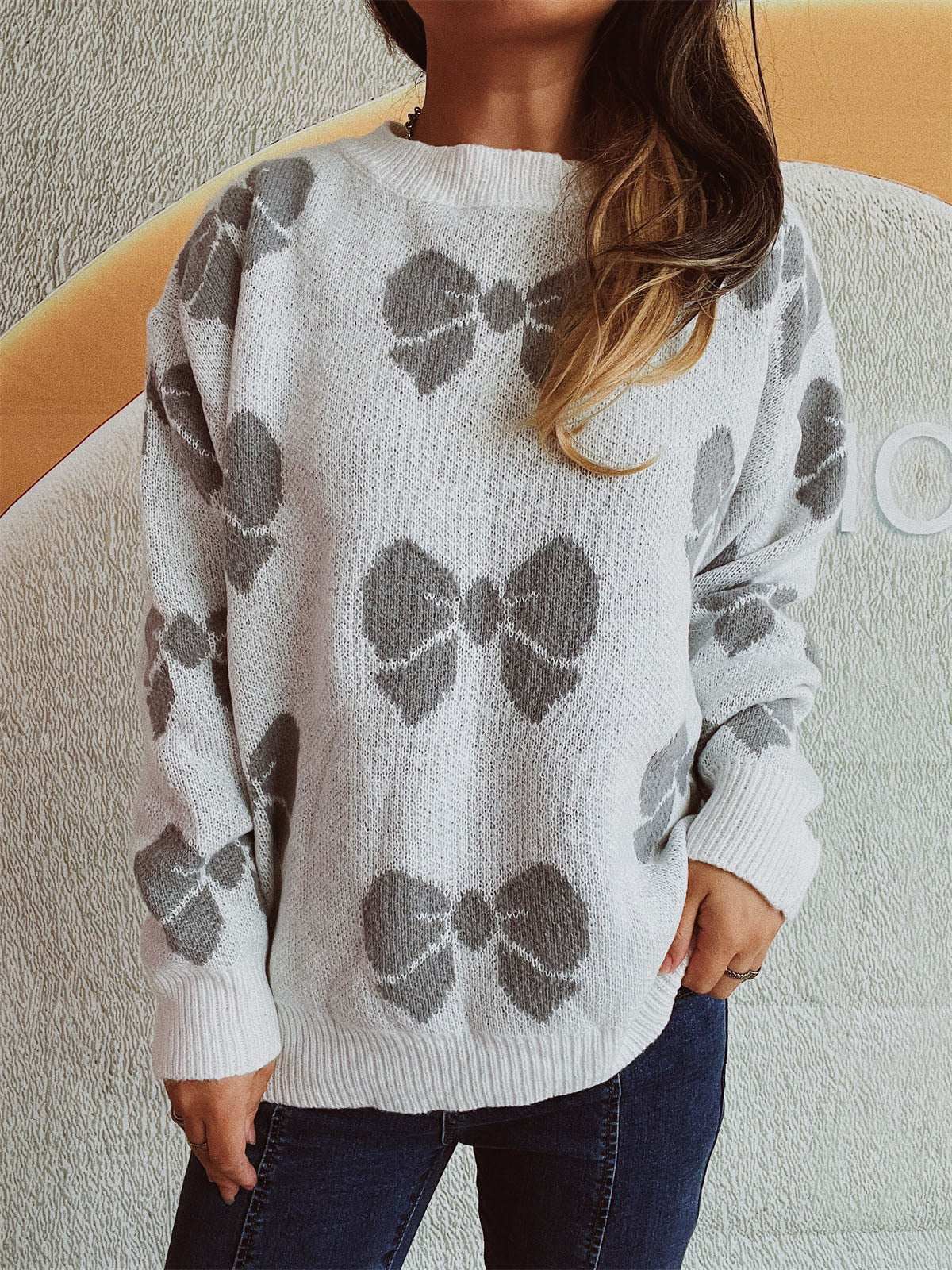 Bow round neck dropped shoulder sweater with bow pattern, moderate stretch, polyester and acrylic blend.