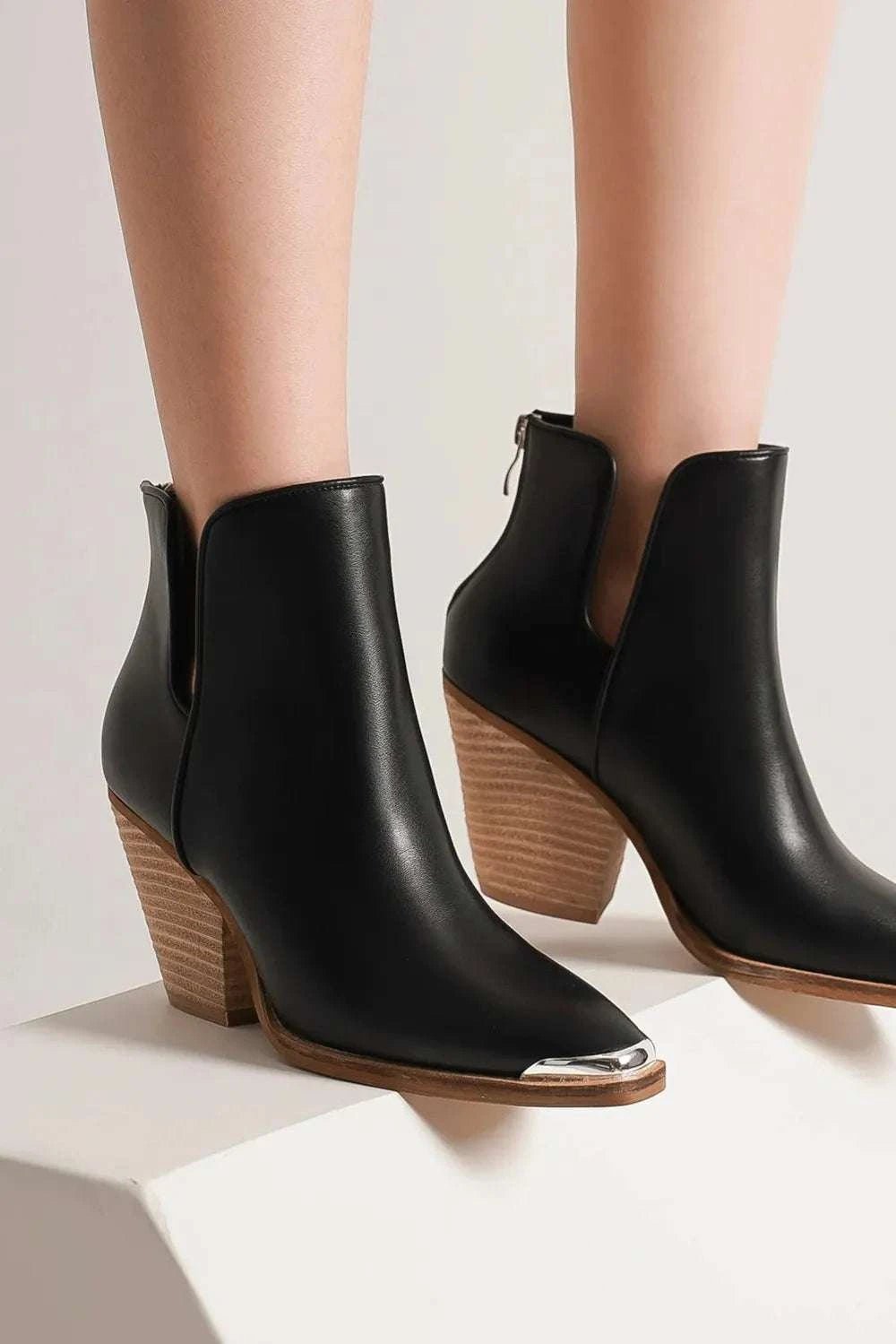 Pointed metal-tip toe block heel ankle boots in faux leather.