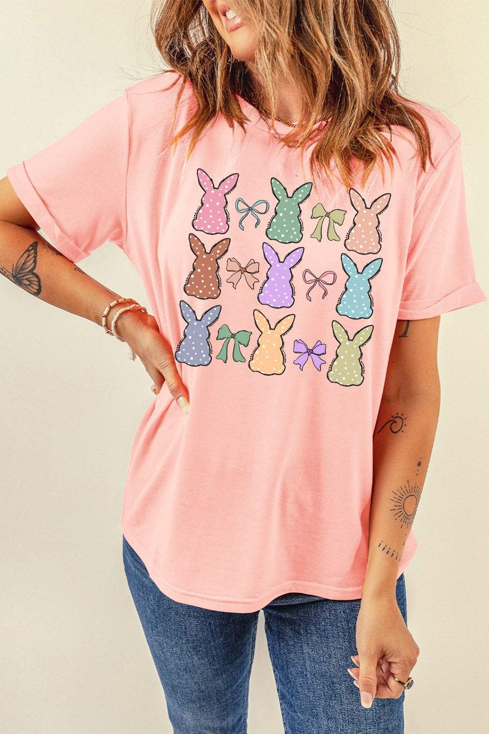 Pink short sleeve t-shirt with multi-colored bunny and bow graphics, made from a polyester-cotton blend.