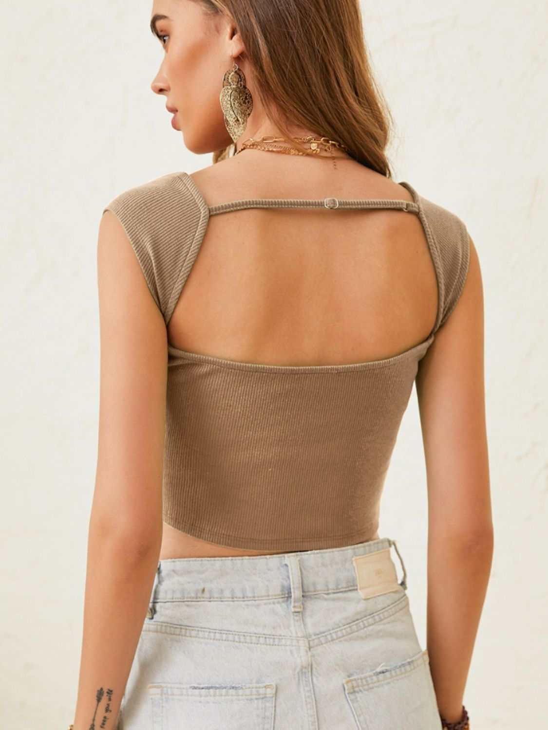 Ribbed cutout cap sleeve crop top in beige, back view.