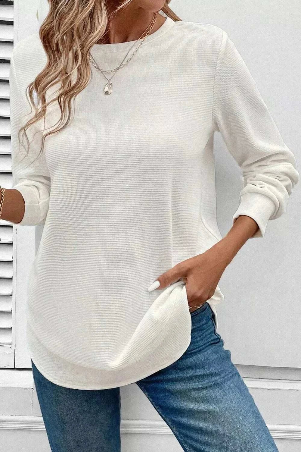 Women's white rounded neck waffle long sleeve top with slight stretch, paired with blue jeans