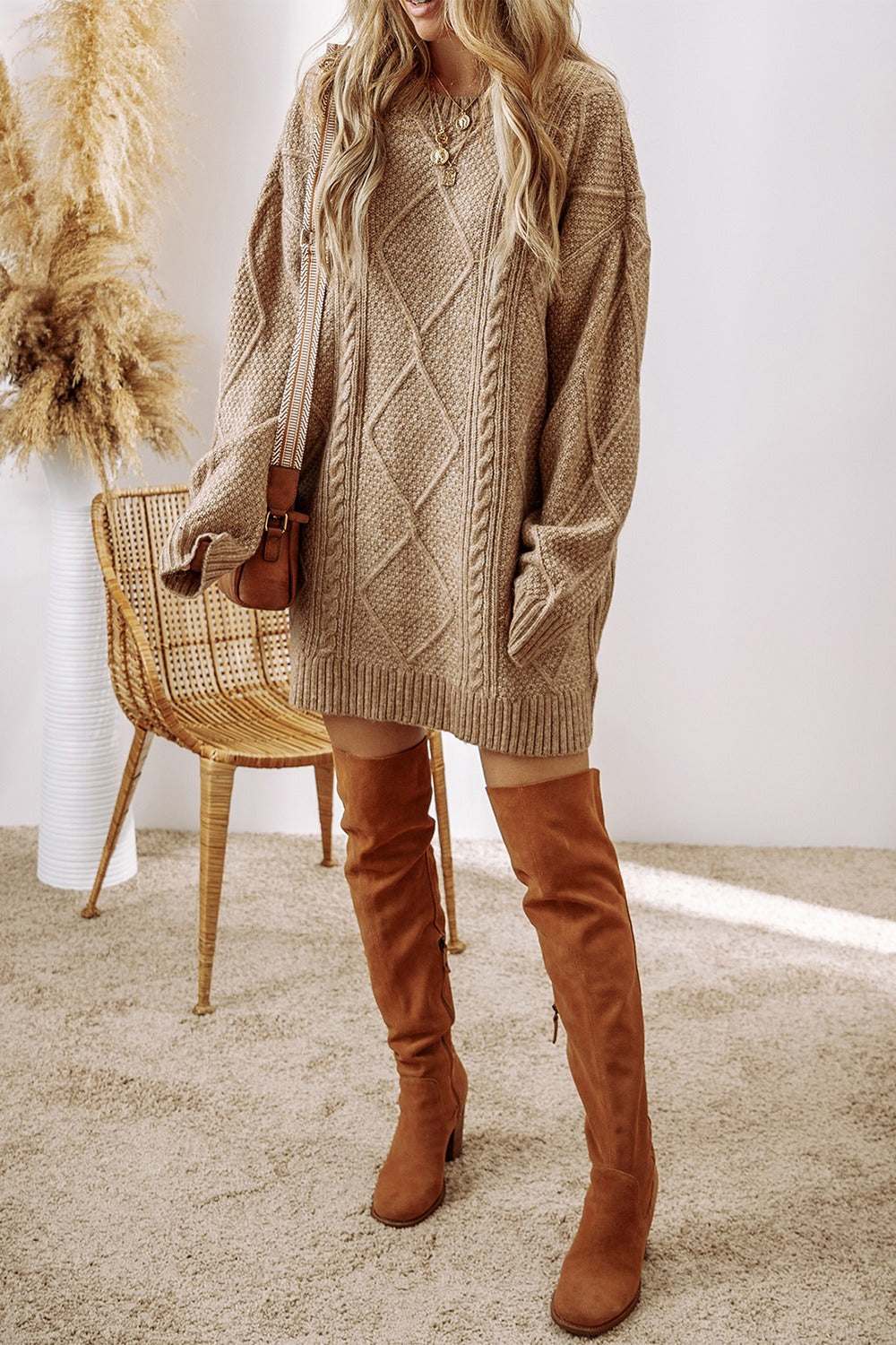 Cable-knit round neck sweater dress in beige with long sleeves and slightly stretchy fit.