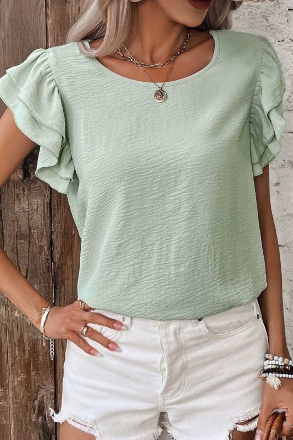 V-Neck ruffled cap sleeve blouse made of 100% polyester.