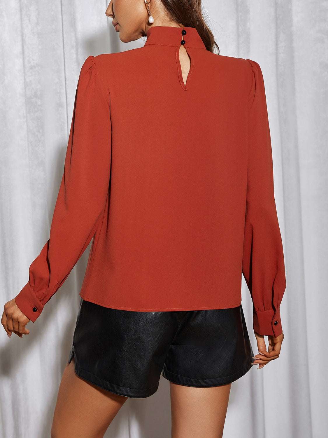 Cutout puff sleeve blouse in red with no stretch and button detail on the back.