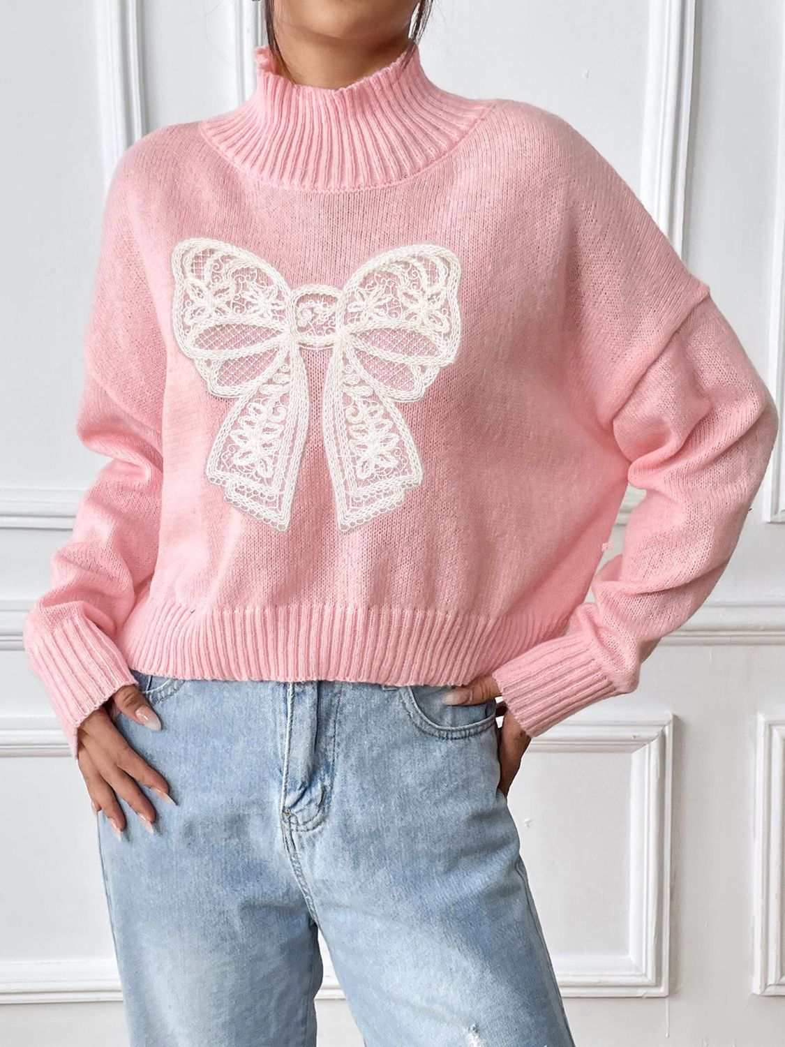 Pink bow turtleneck long sleeve sweater, slightly stretchy polyester material.