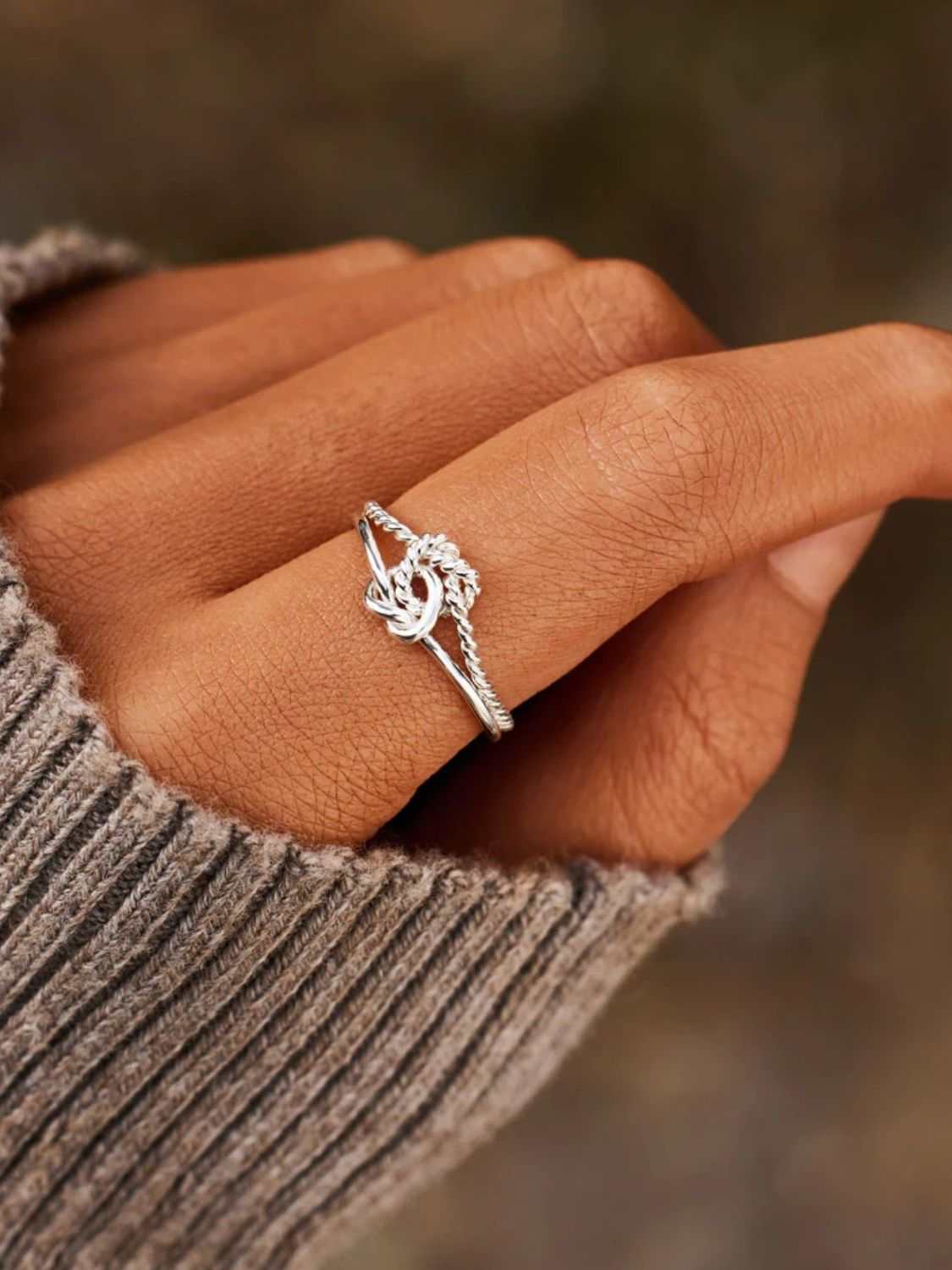 925 Sterling Silver adjustable knotted ring on a hand, includes matching box.