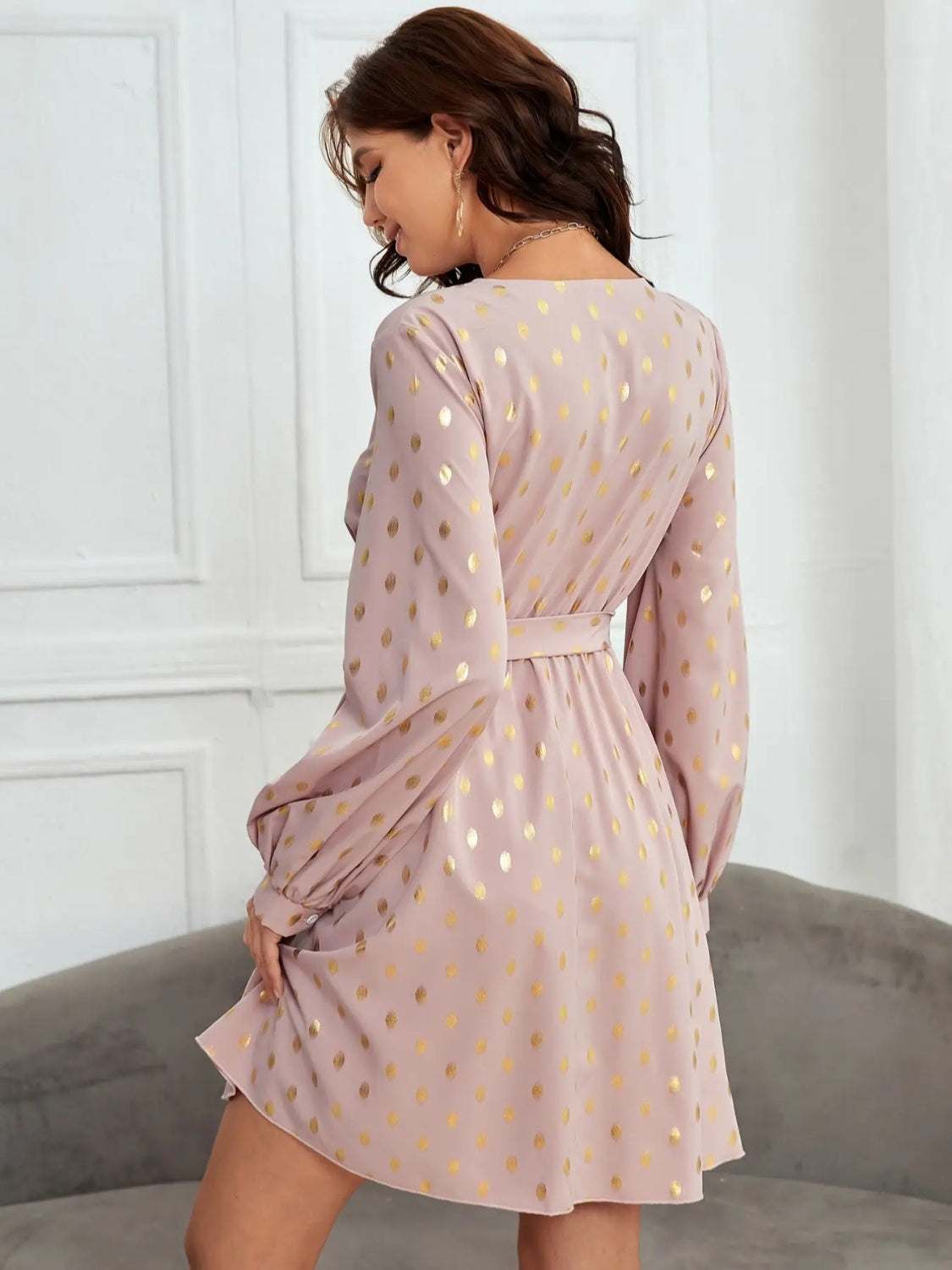 Tied printed surplice long sleeve dress in light pink with gold dots.