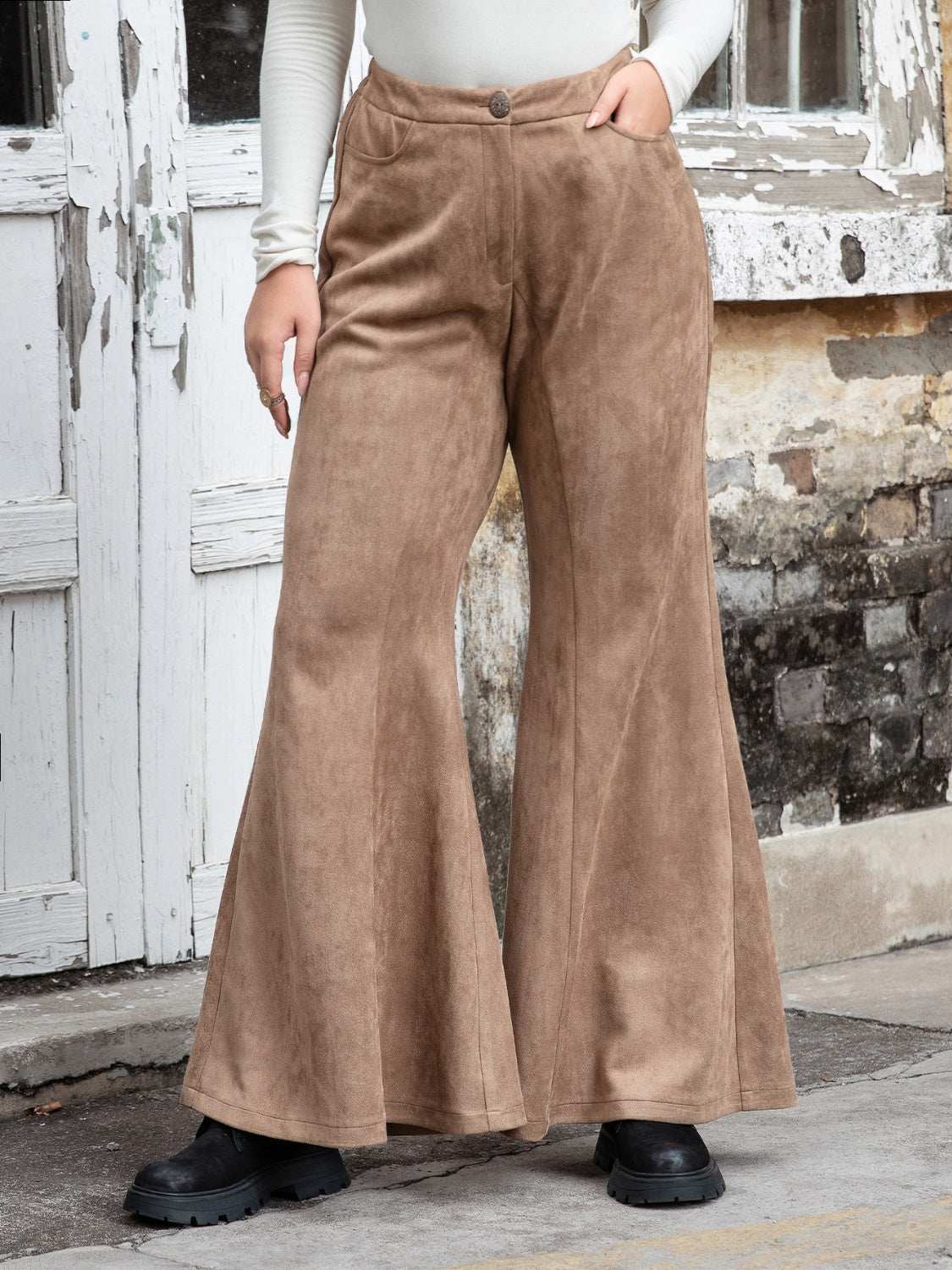 Plus size pocketed flare pants in brown, featuring a button closure and flared legs.