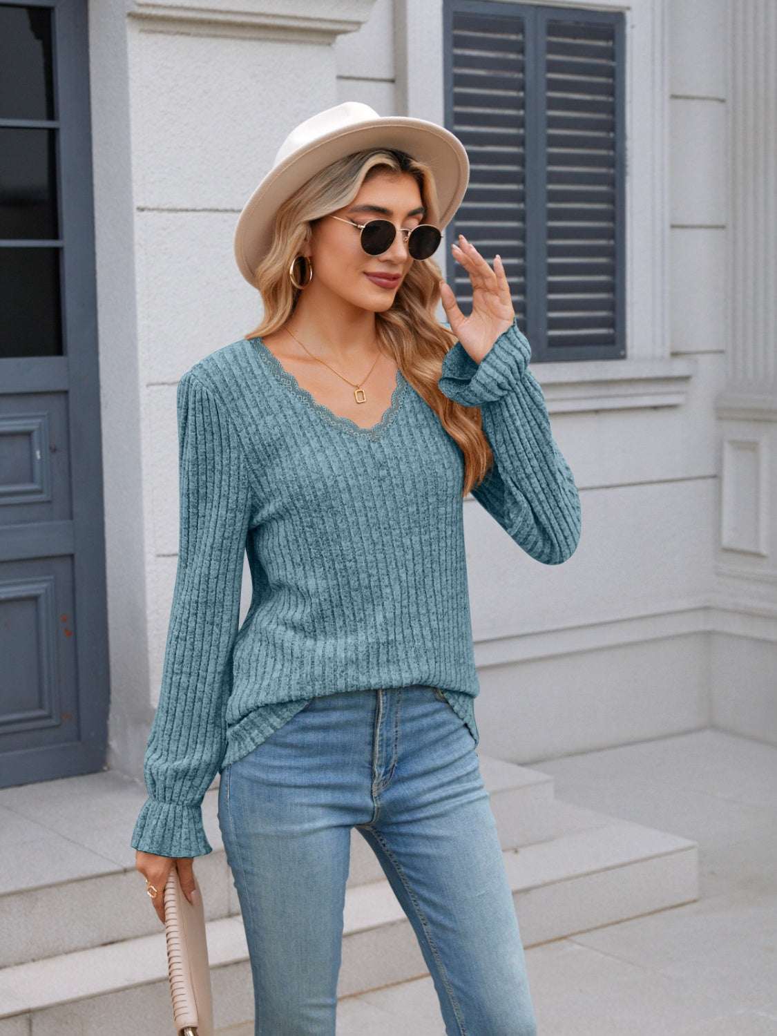 Lace detail V-neck long sleeve T-shirt in blue with ruffled design, worn by a woman outdoors.