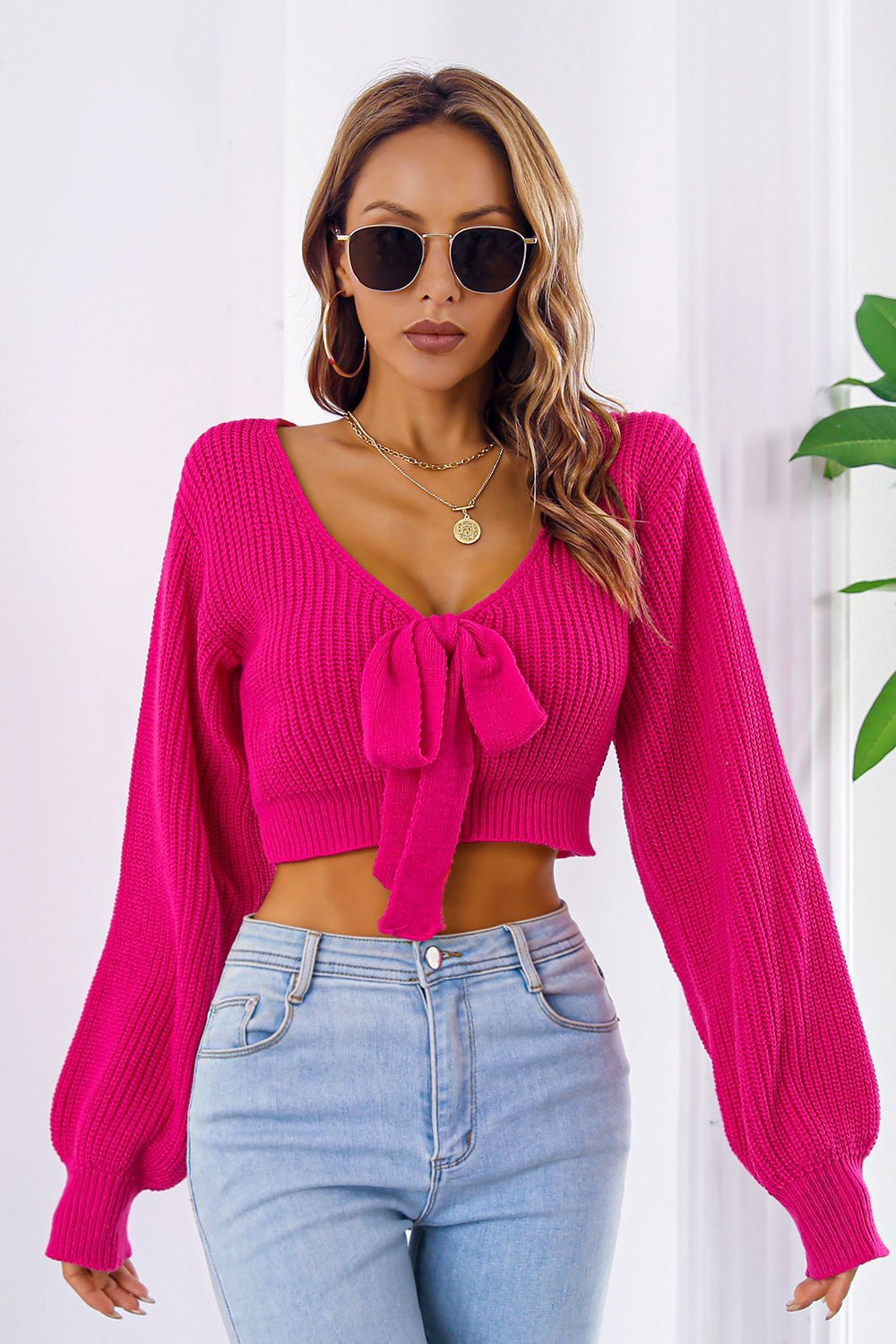 Bow V-Neck long sleeve cropped sweater in vibrant pink with tie detail.