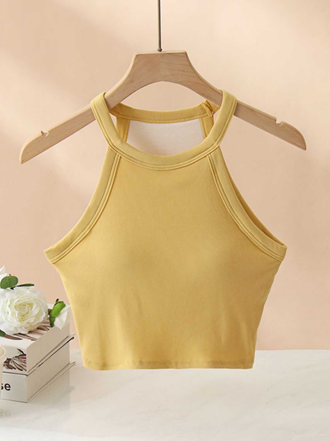 Ribbed Grecian neck cropped tank with chest pads on hanger.