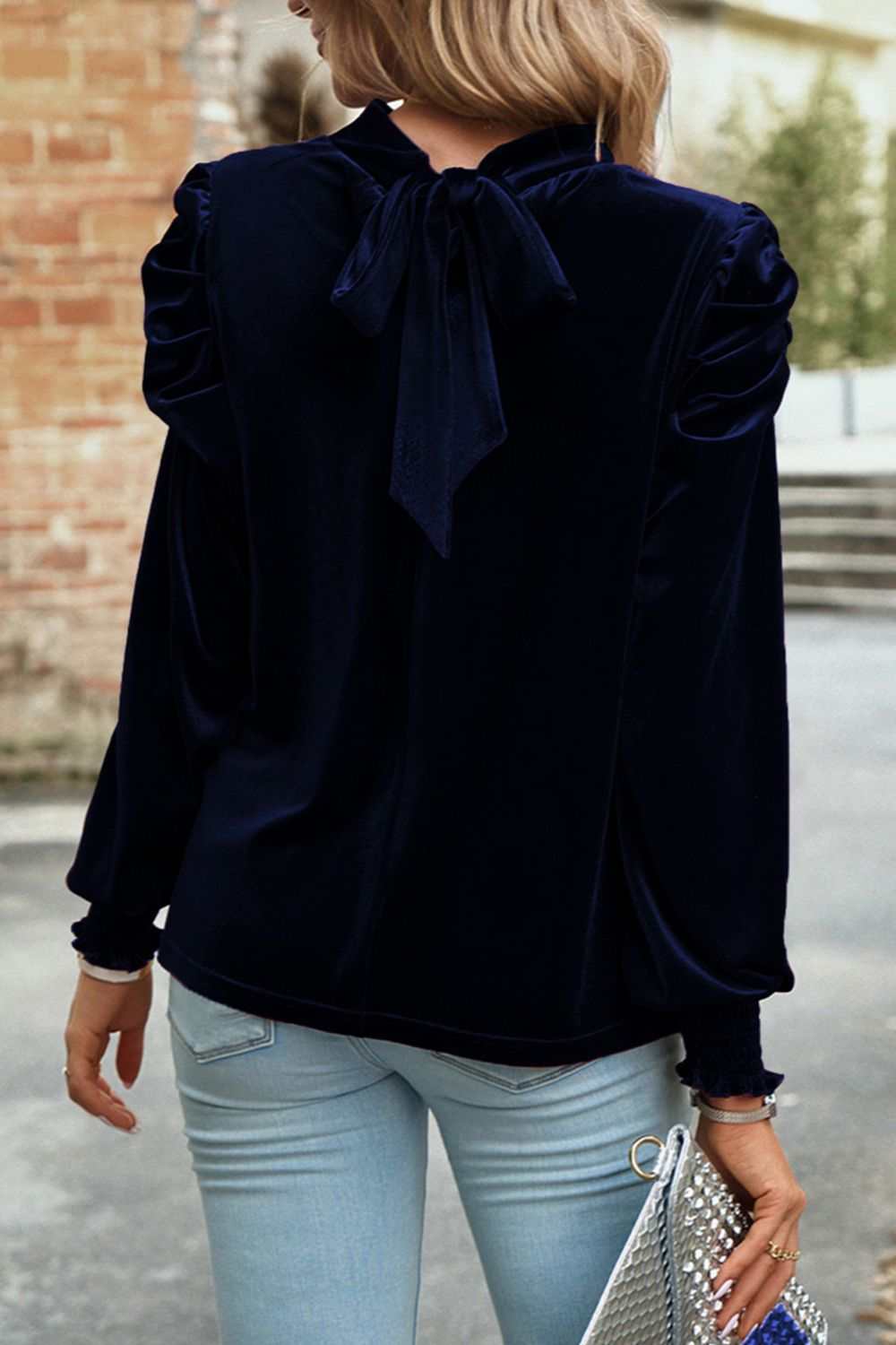 Mock neck long sleeve velvet blouse with tie detail, worn by a model.