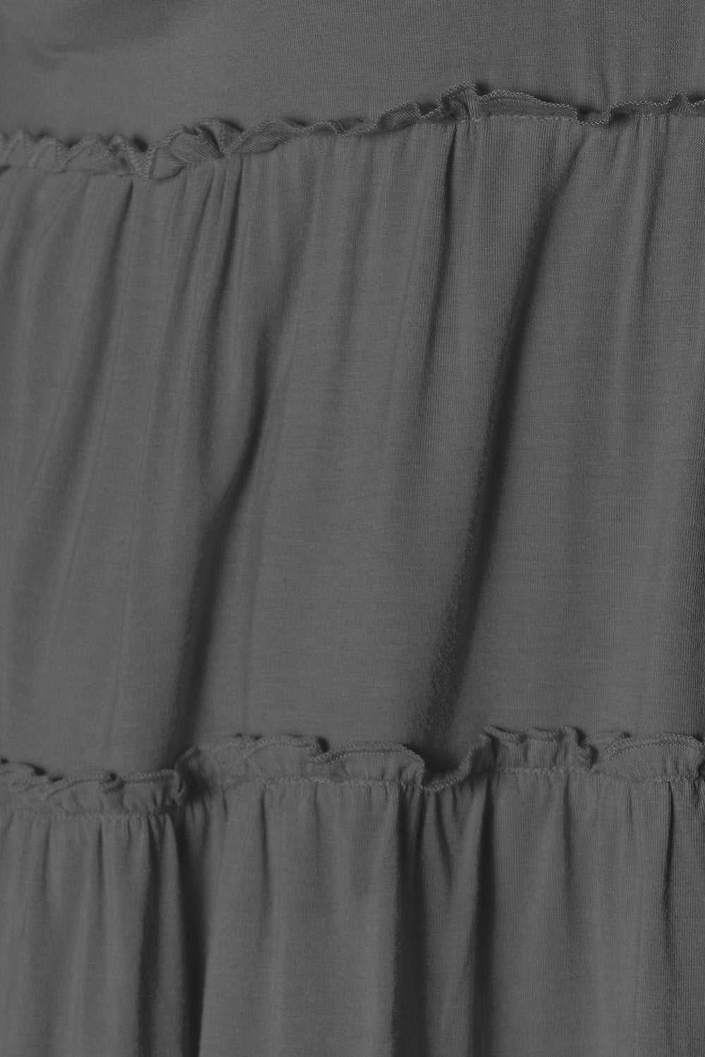 Half button long sleeve blouse with ruffle hem in opaque fabric.