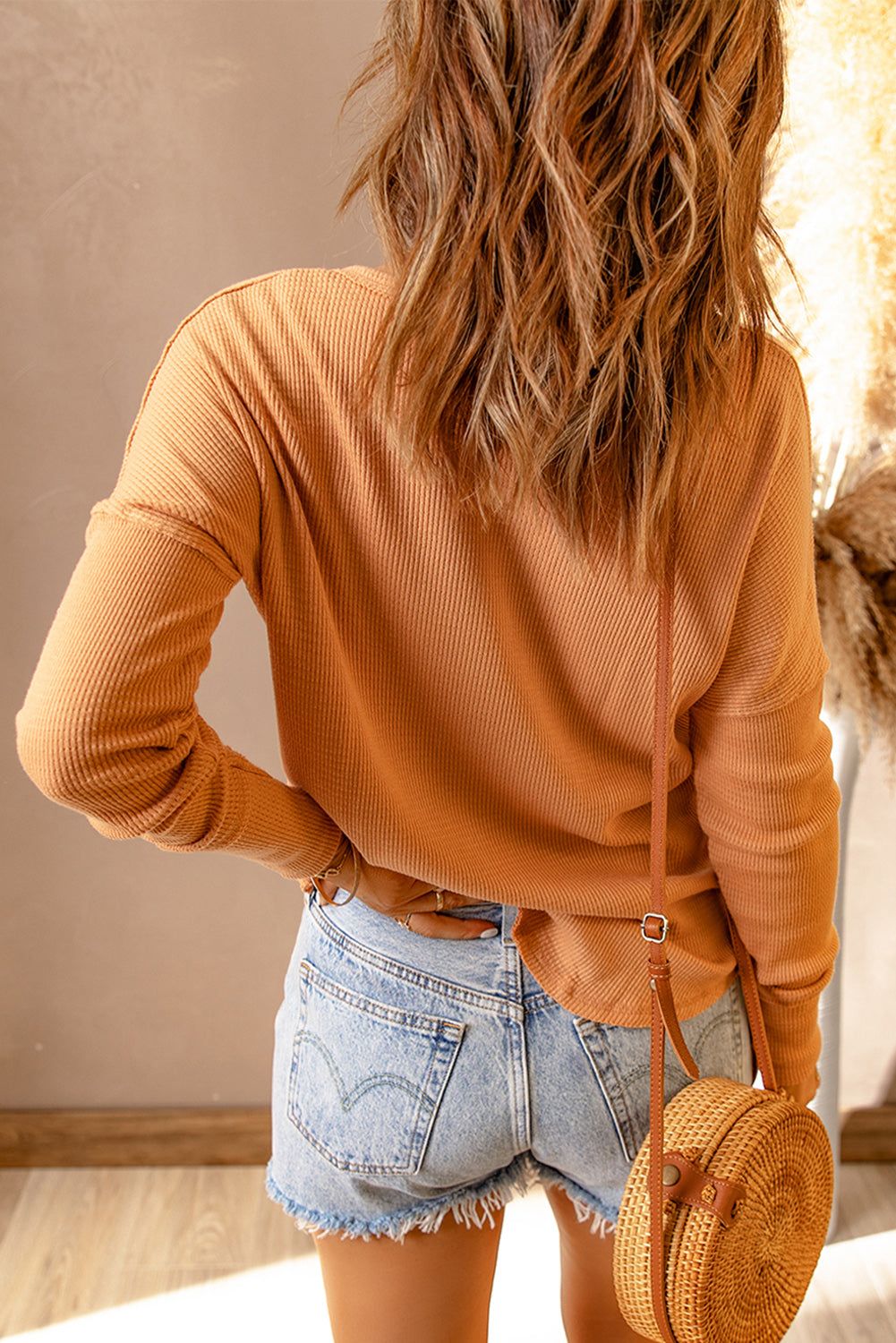 Women's full size half button drop shoulder t-shirt in a warm tone, shown from the back.