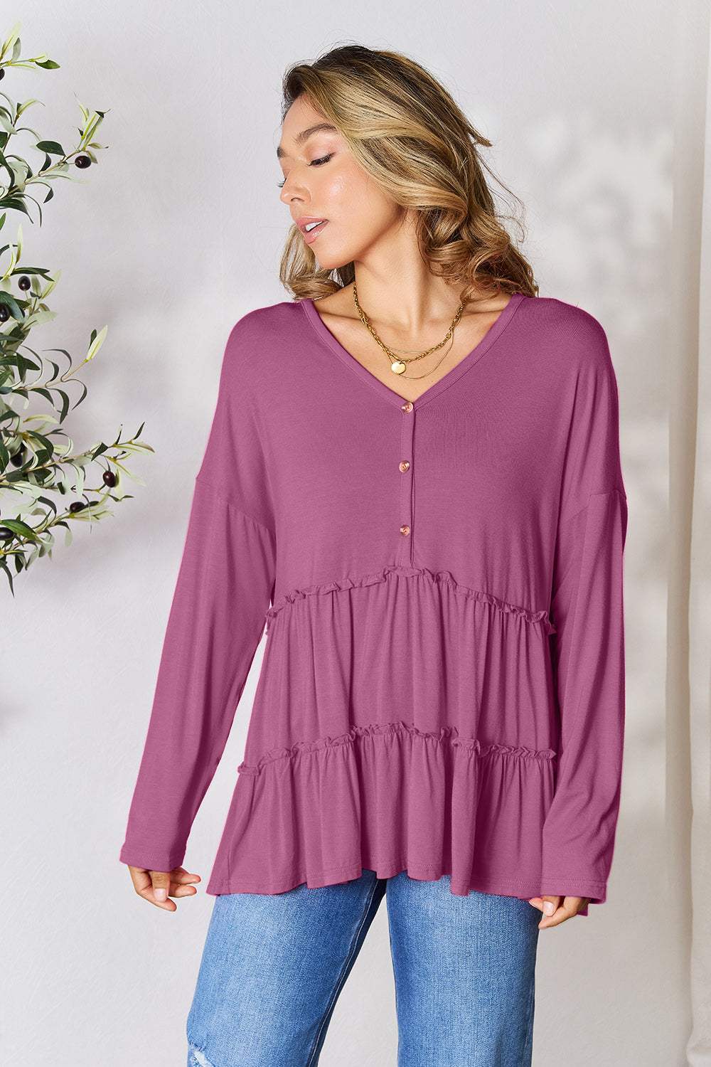 Half button long sleeve ruffle hem blouse in purple with buttoned front and slightly stretchy fabric.