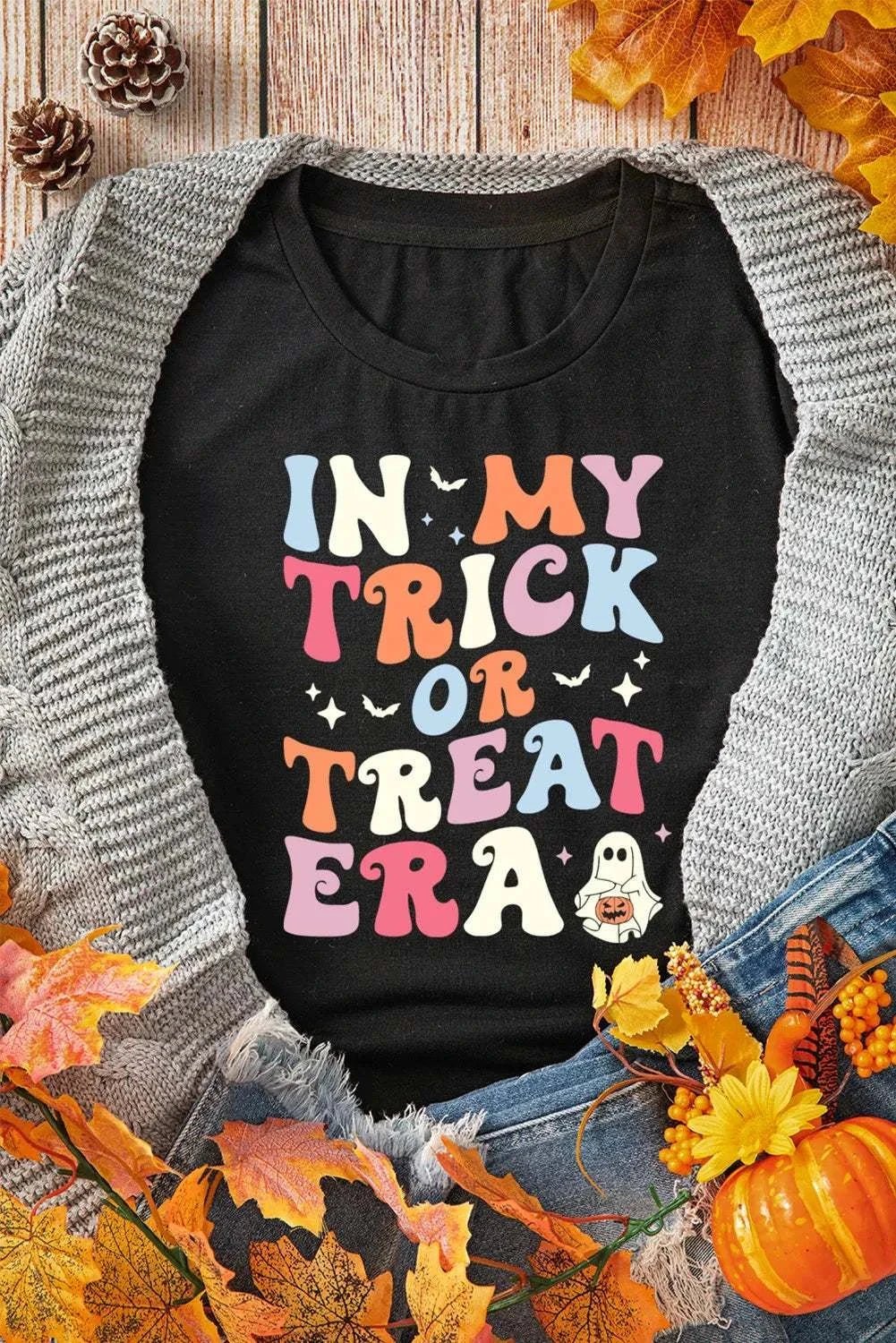 Letter graphic round neck short sleeve t-shirt with colorful text design on a black fabric background.