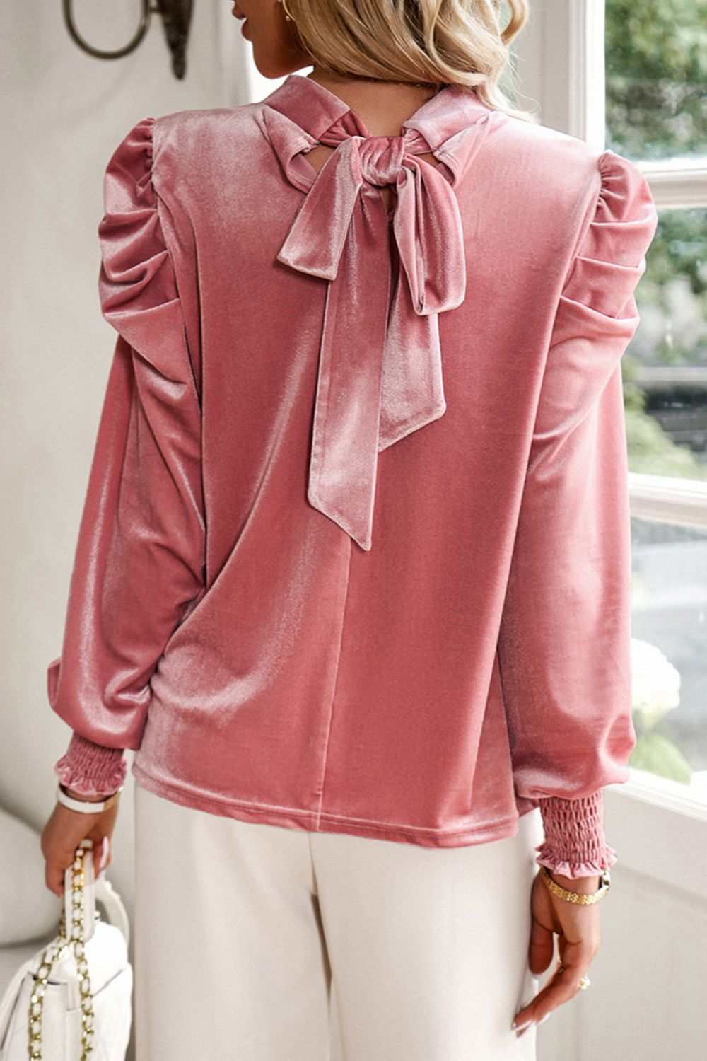 Mock neck blush pink velvet blouse with tie-up detail and long sleeves.