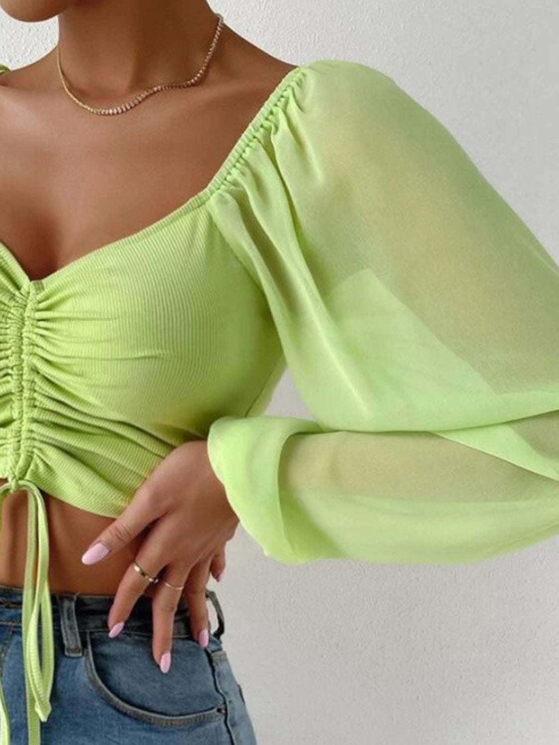 Drawstring sweetheart neck cropped top in light green with semi-sheer sleeves.