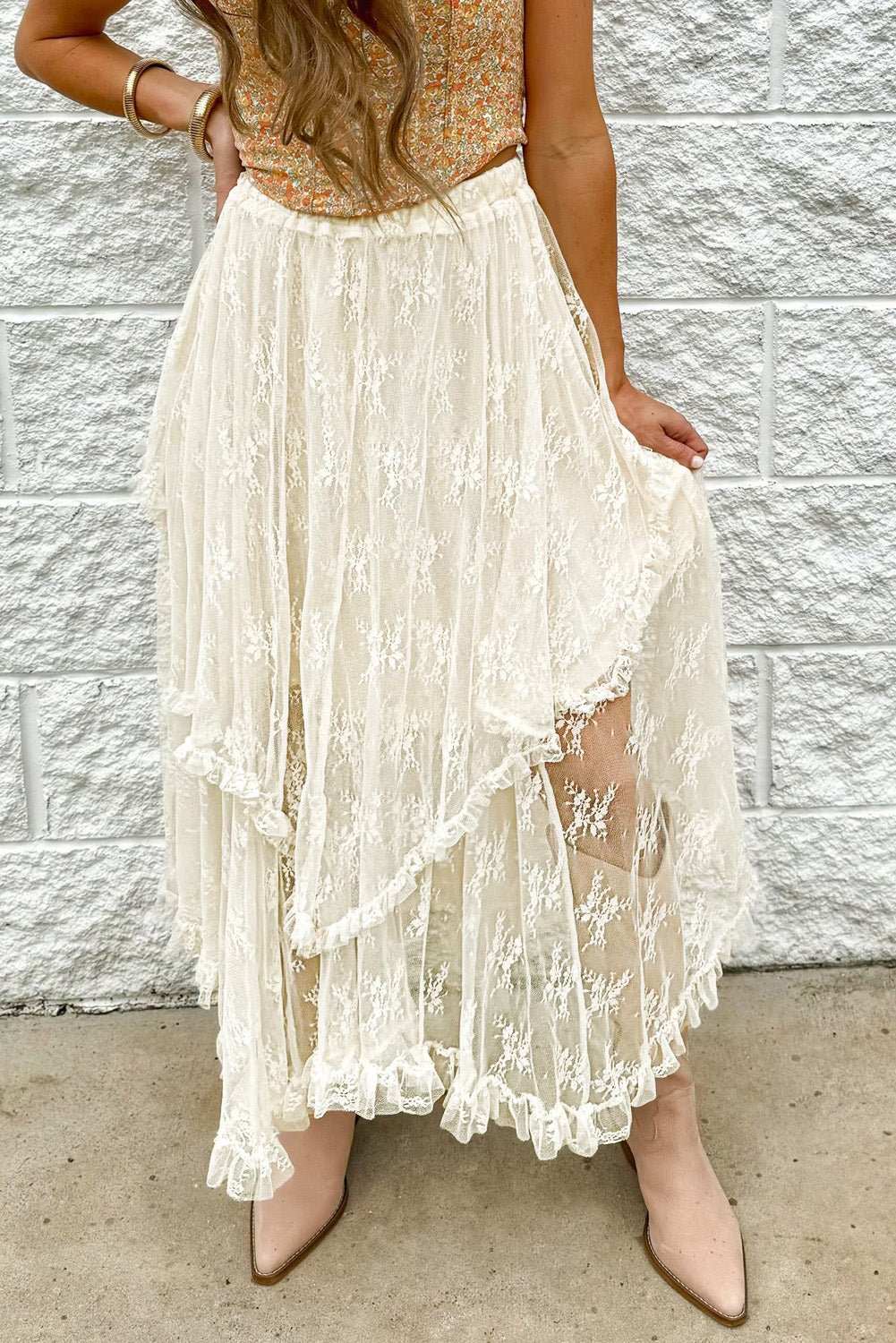 Lace tiered midi skirt with semi-sheer fabric, partially lined, featuring intricate lace design.