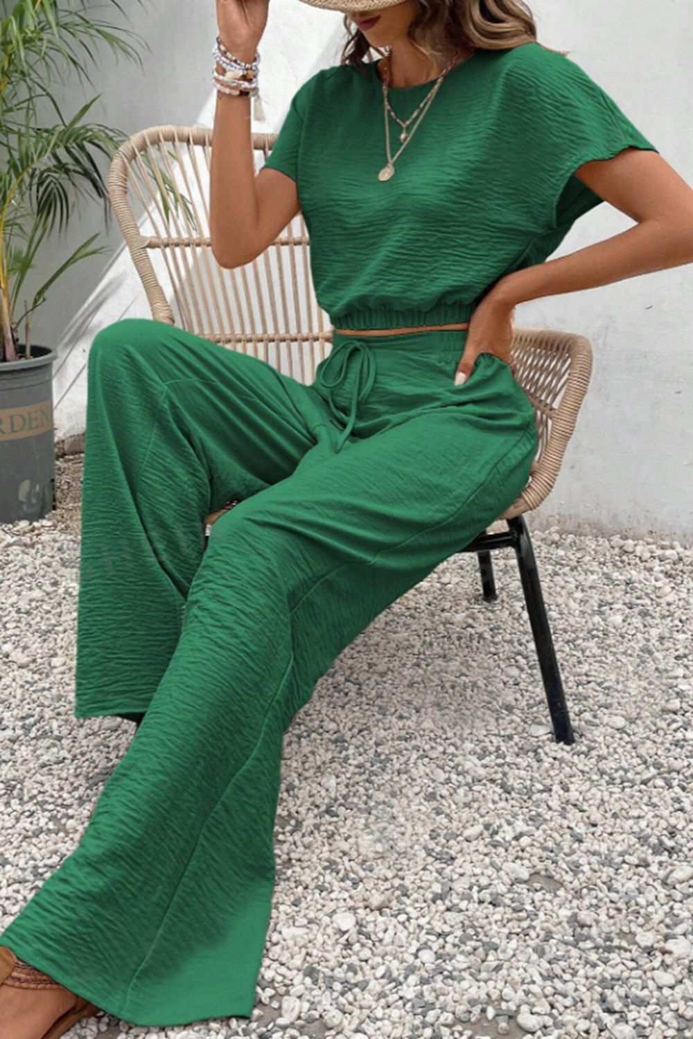 Round neck short sleeve top and pants set in green, buttoned and tied, made of 100% polyester.