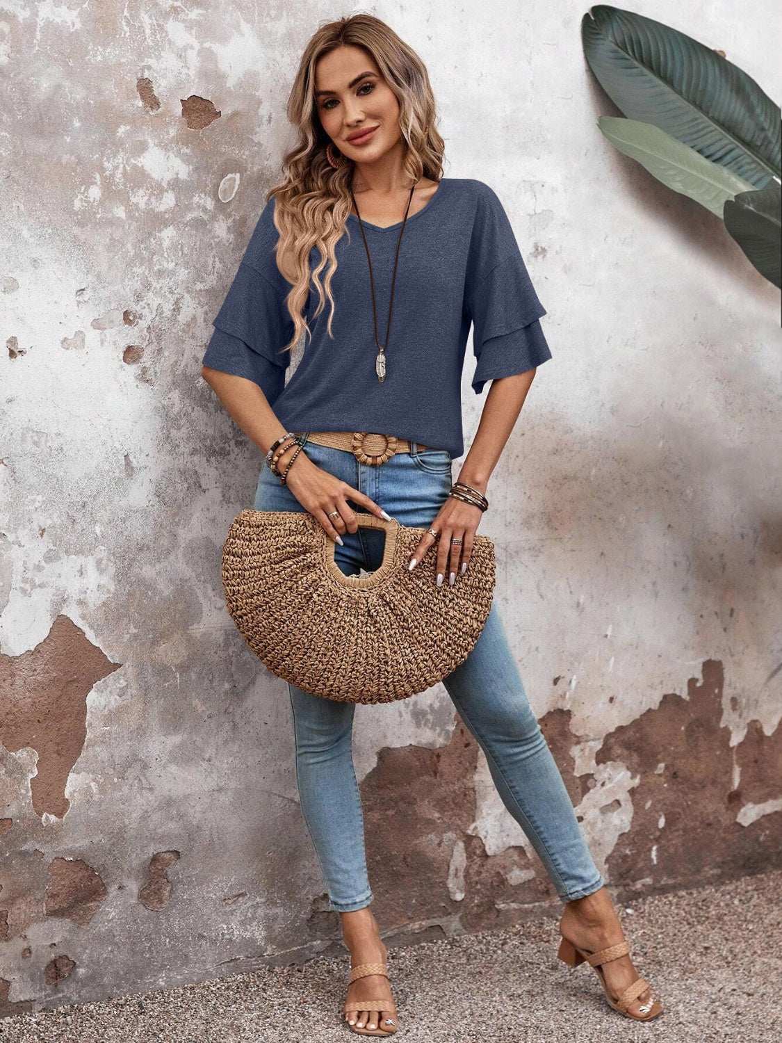 V-Neck half sleeve blouse in blue, paired with light jeans and sandals.