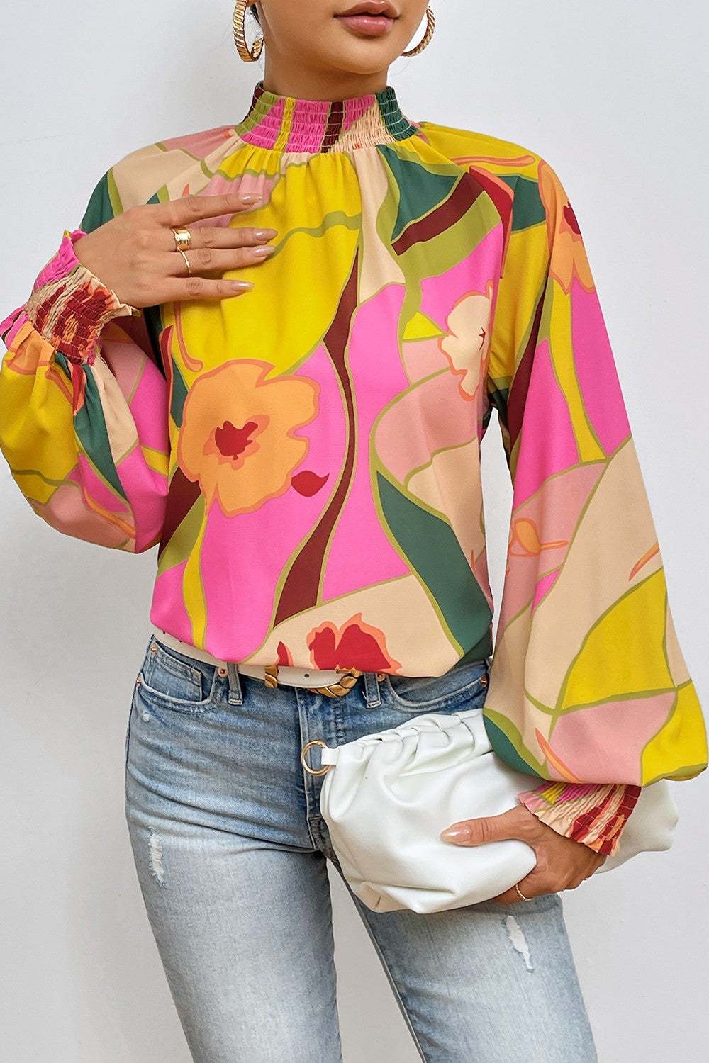 Floral smocked lantern sleeve mock neck blouse in vibrant colors.