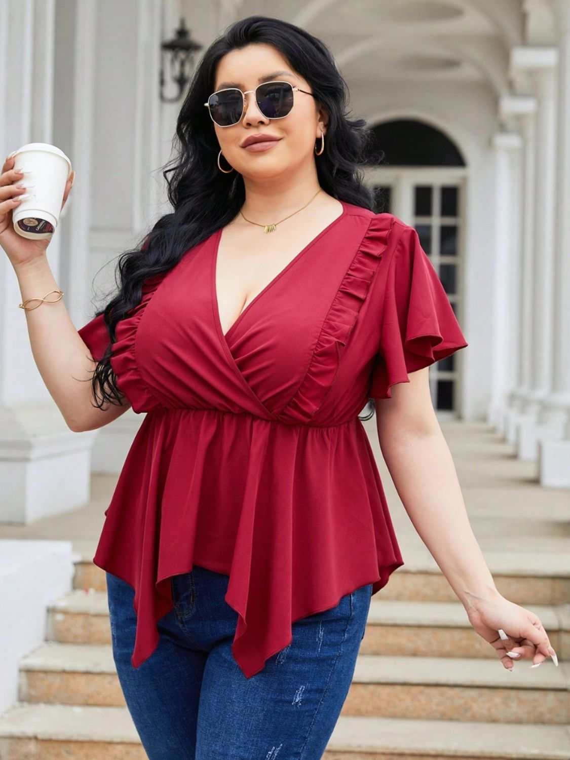 Plus size frill surplice flutter sleeve blouse in red, worn by a person outdoors.
