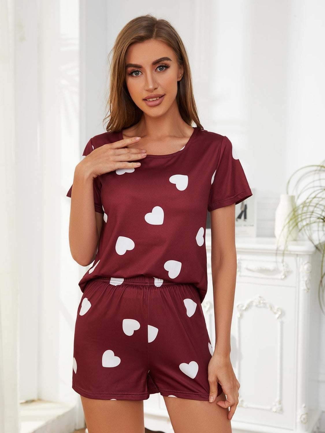 Woman wearing a maroon heart round neck top and shorts lounge set.