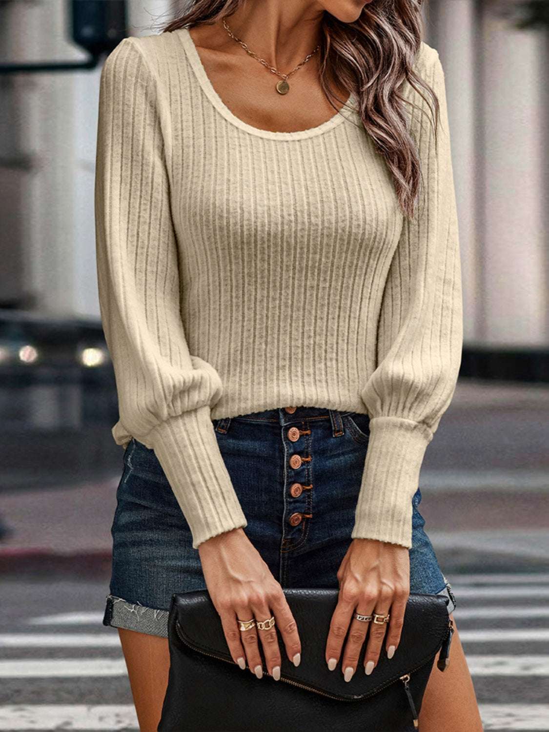 Shiny ribbed round neck lantern sleeve knit top worn with denim skirt.