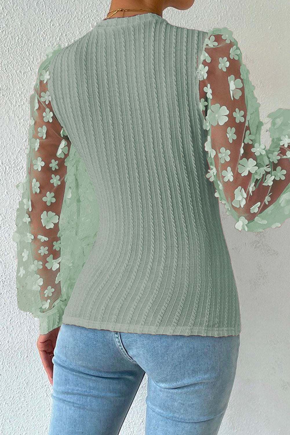 Textured applique long sleeve blouse with floral cable-knit design and round neck.