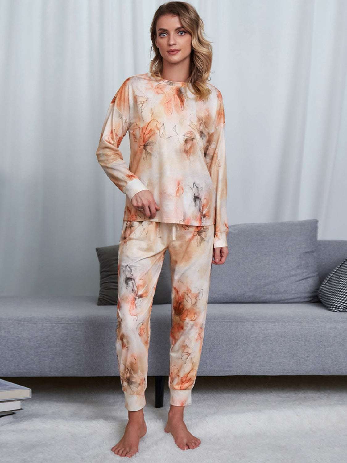 Shiny tie-dye round neck top and pants lounge set in orange and beige tones.
