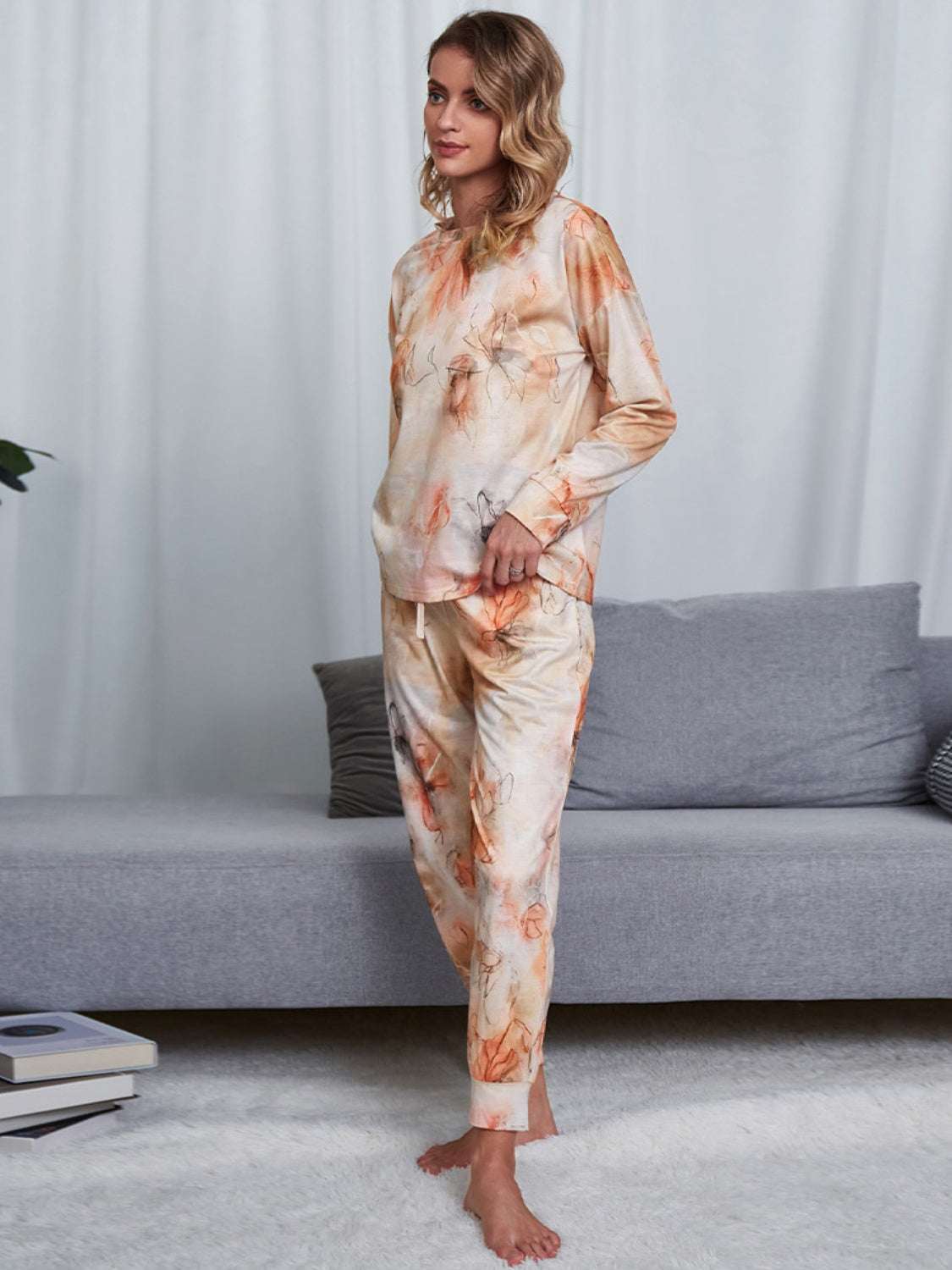 Shiny tie-dye round neck top and pants lounge set in orange and cream tones, slightly stretchy with opaque fabric, made of polyester and spandex.