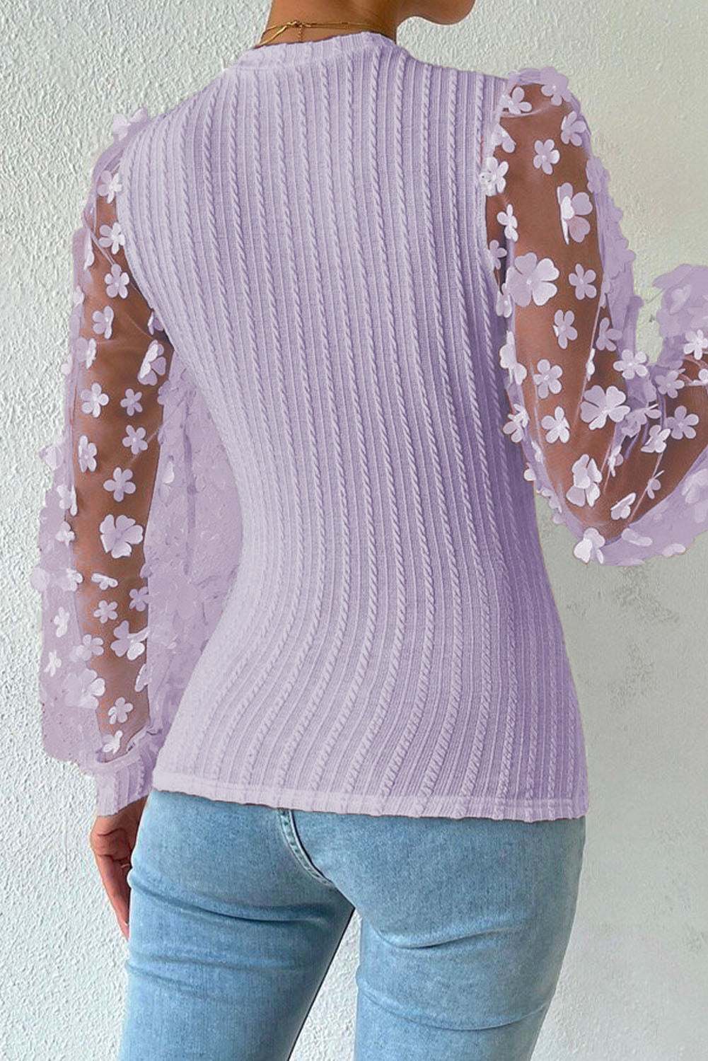 Textured applique long sleeve blouse with cable-knit design and floral sheer sleeves.