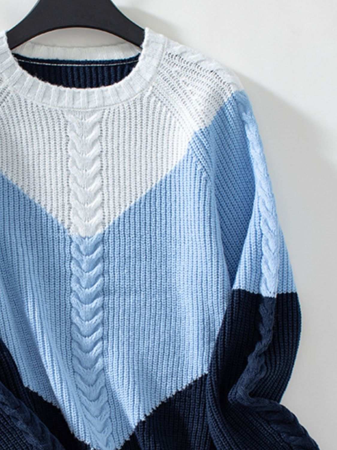 Color block round neck long sleeve sweater in blue and white tones.