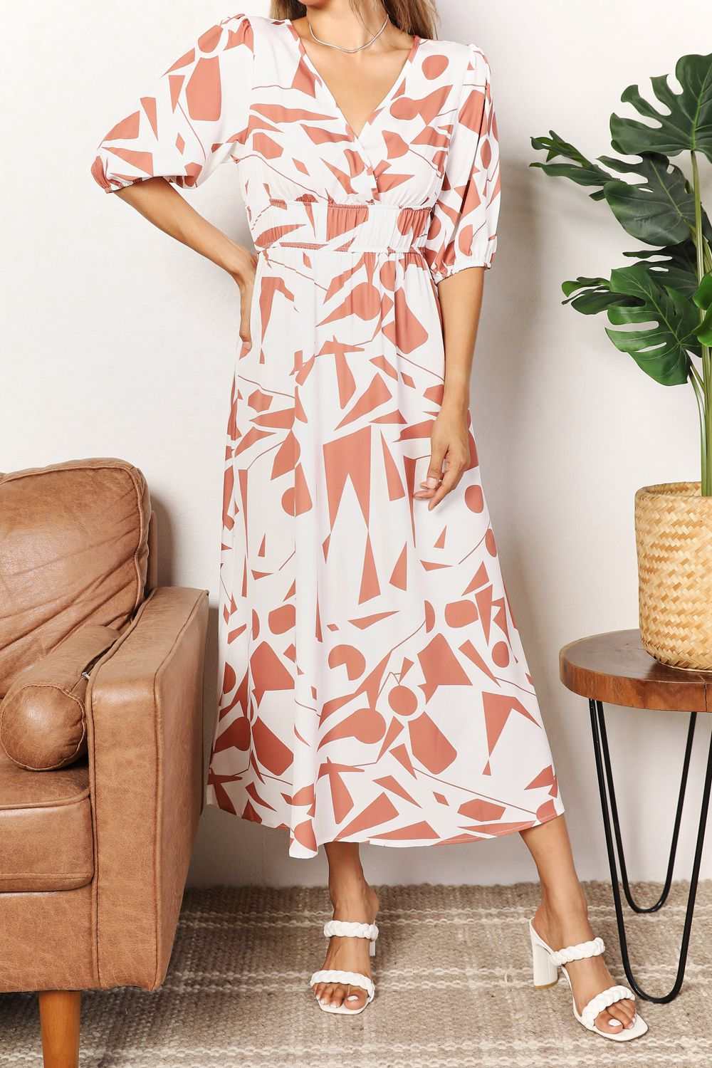 Printed surplice balloon sleeve dress with midi length and elegant neckline.