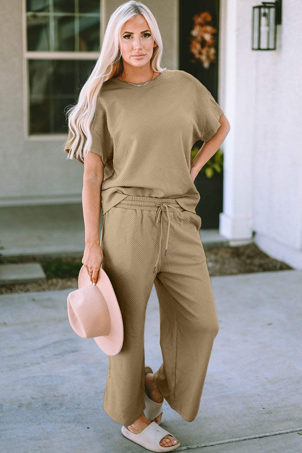 Two-piece textured short sleeve top and pants set with drawstring waist, slightly stretchy fabric, made of 95% polyester and 5% spandex.