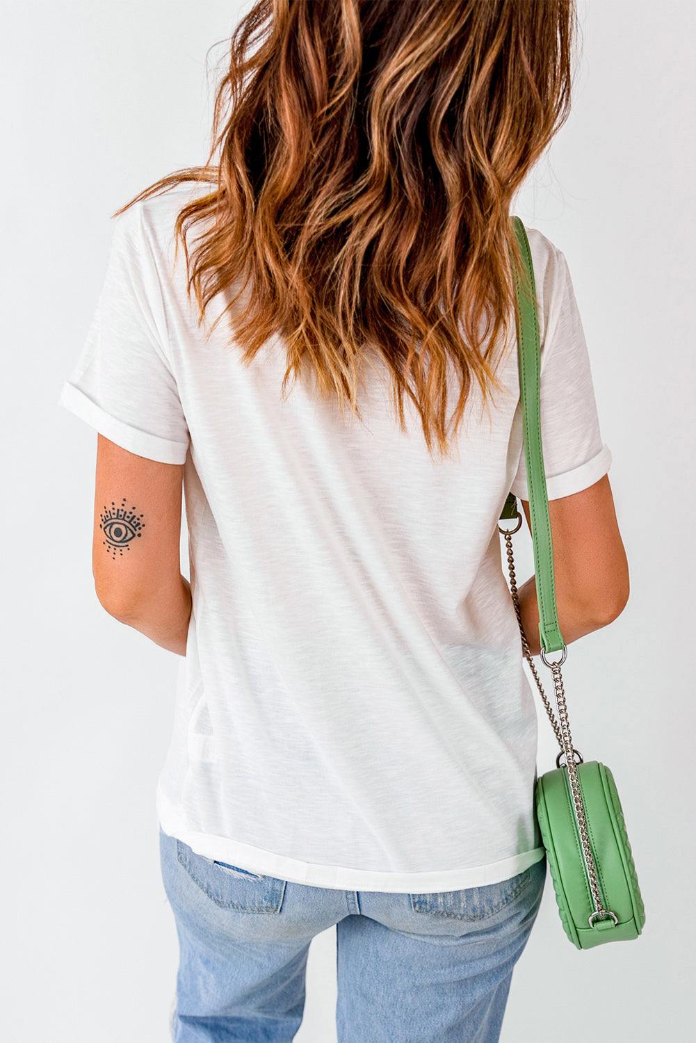 Back view of woman wearing graphic round neck short sleeve t-shirt with a green bag.
