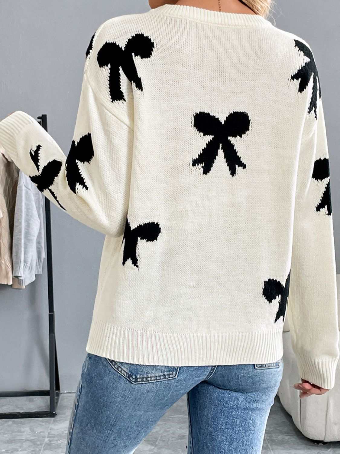 Perfee Bow Graphic round neck sweater with black bow pattern and long sleeves.
